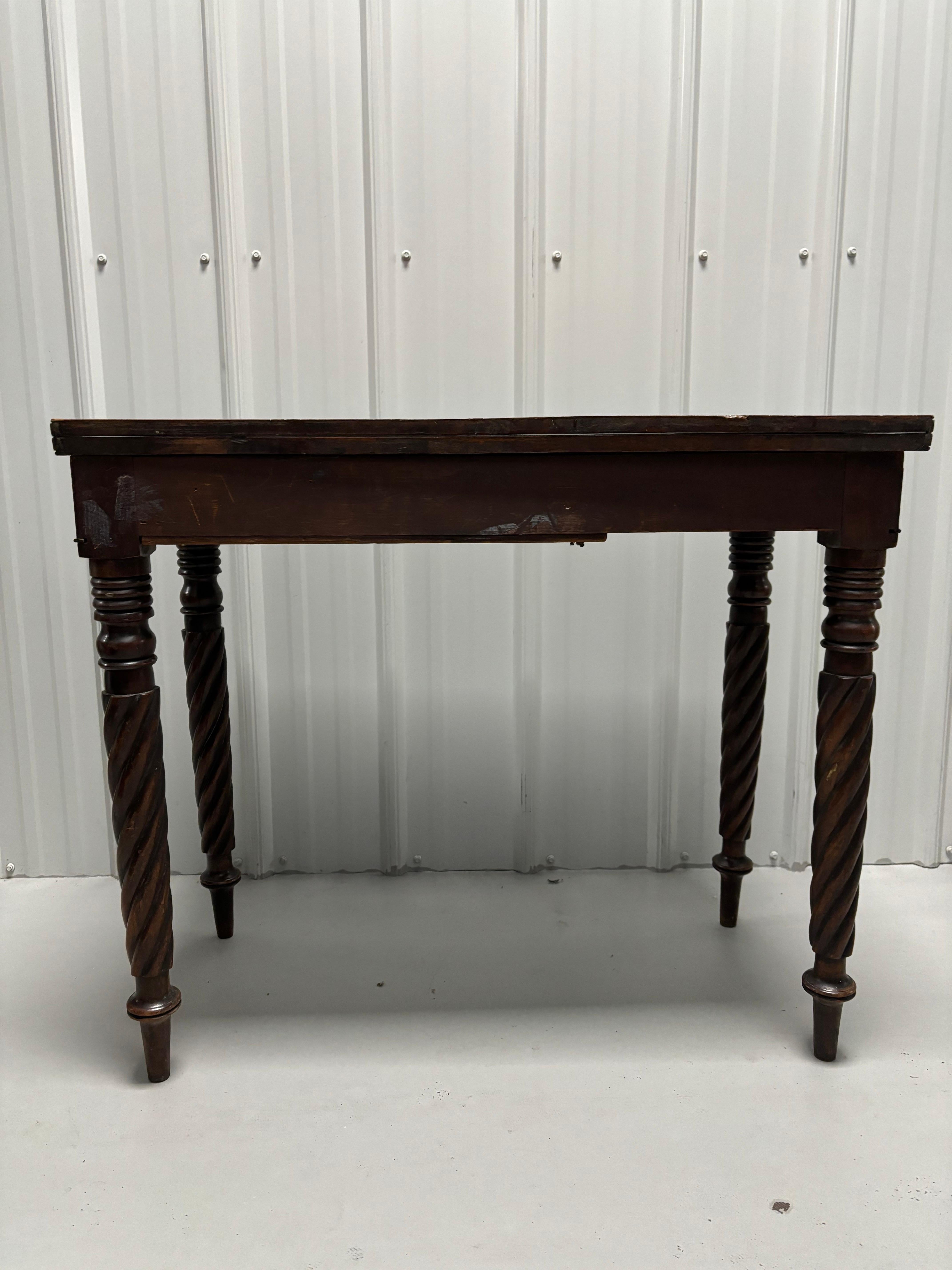 19th Century English Mahogany Game Table with Rope Twist Legs 
An antique game table offers mahogany construction with fold over and twist top, raised on carved rope twist legs.

33.5