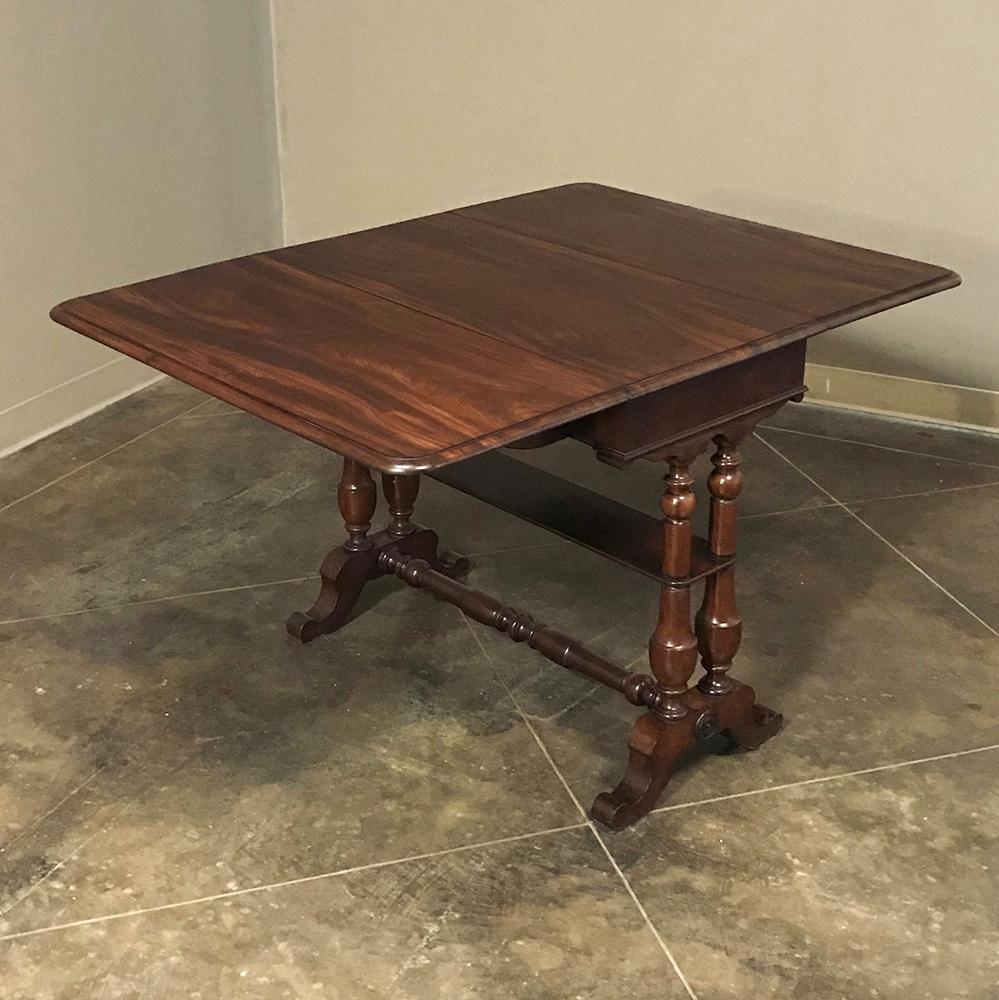 This handsome 19th Century English mahogany gateleg drop leaf table was crafted from the select, exotic imported mahogany that was so prized during the 1800s in Europe. Turned legs connected with turned stretchers provide support, and the legs on