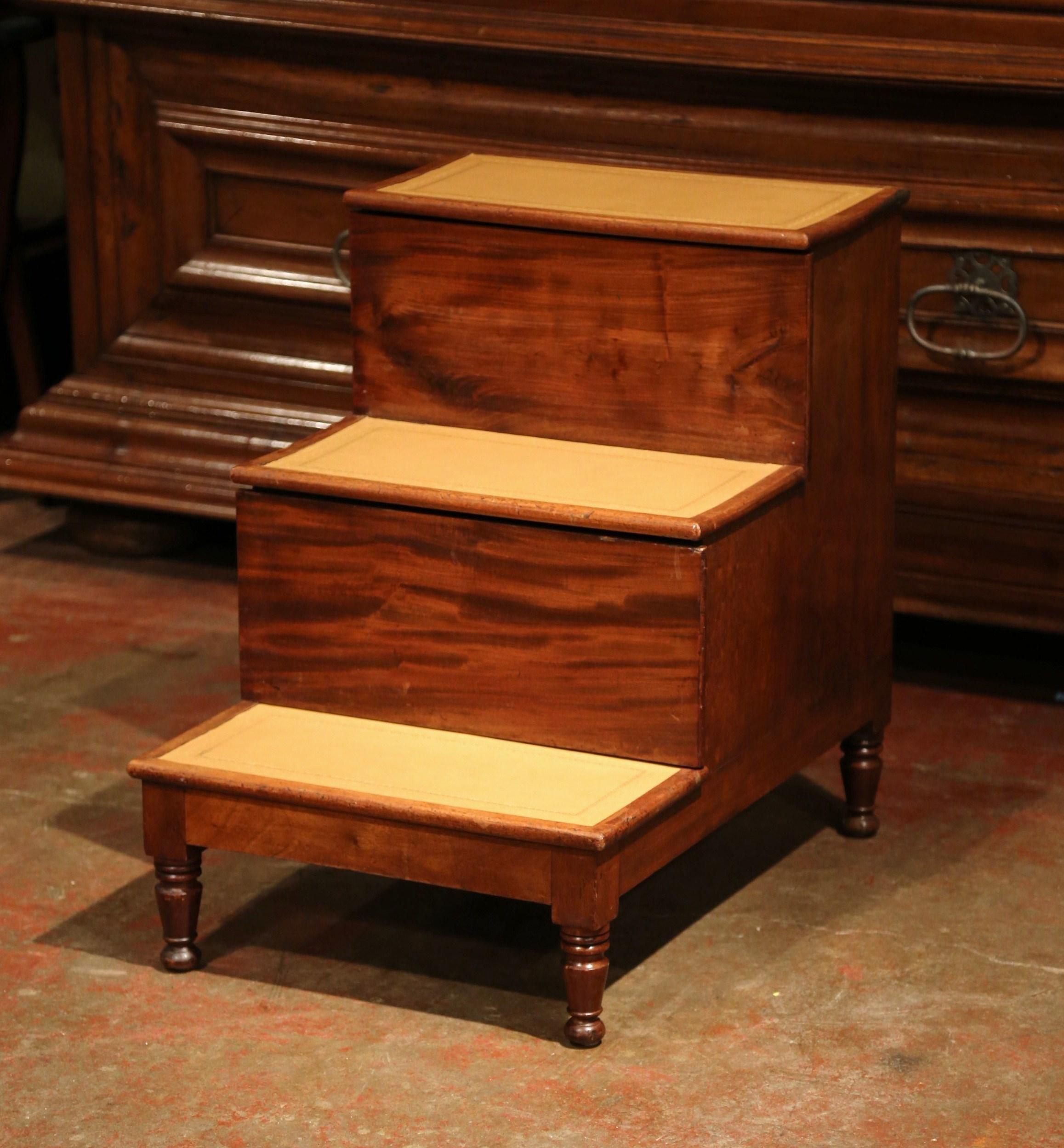 This practical Regency set of library stairs was created in England, circa 1870. The antique utilitarian ladder stands on four small turned legs; each of the three stairs has been re-upholstered with a brown leather, further embellished with an