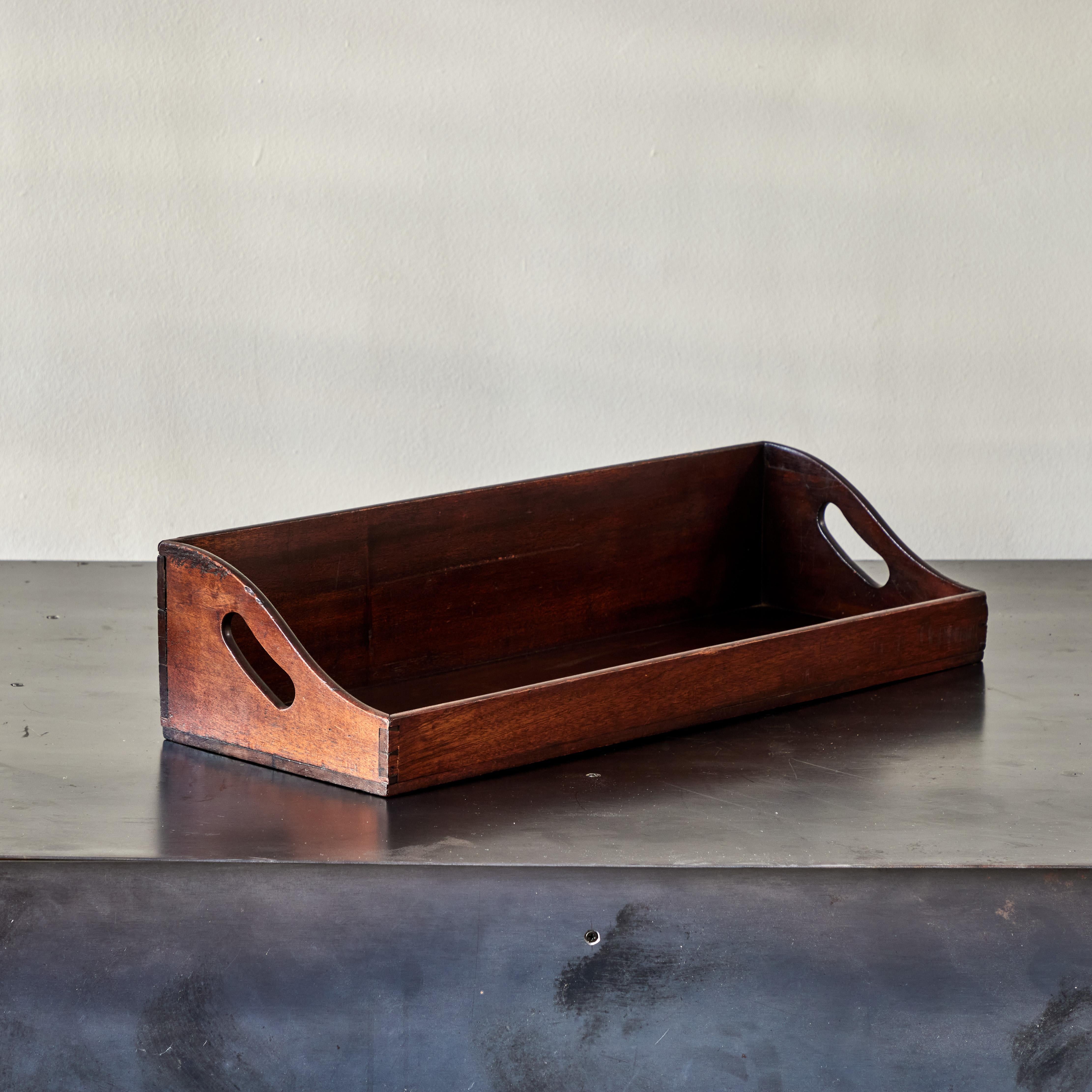 19th-century English mahogany library tray with handles. Perfect for organizing or display, this handsome decorative accent has a deep rich patina and scholarly flair. 

England, circa 1860

Dimensions: 26W x 10D x 6H.