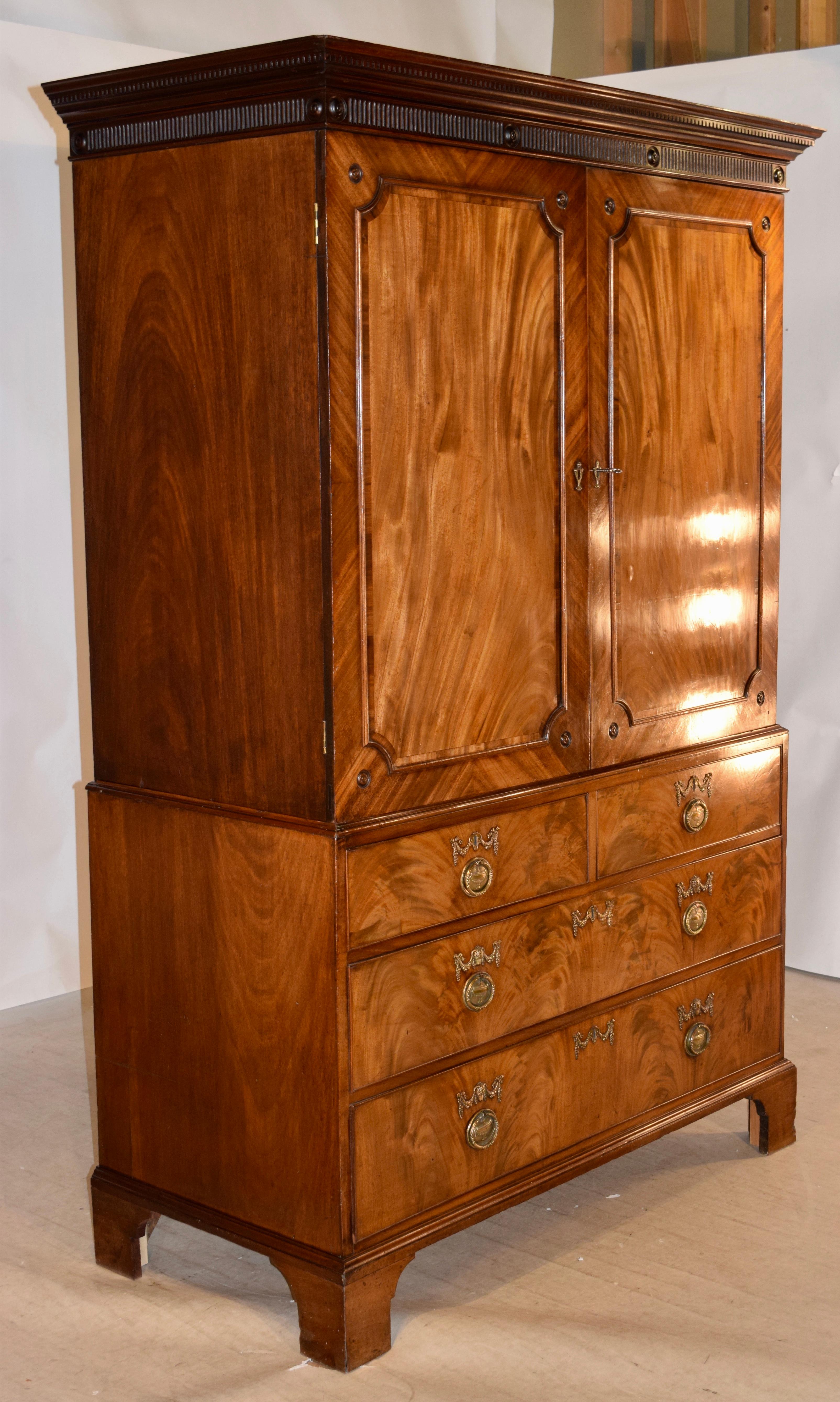 Georgian linen press made from beautifully figured mahogany. The top is finished with a substantial crown over fluted molding. The linen press is two-piece, with simple mahogany sides. The top portion has beautifully figured front doors with panels,