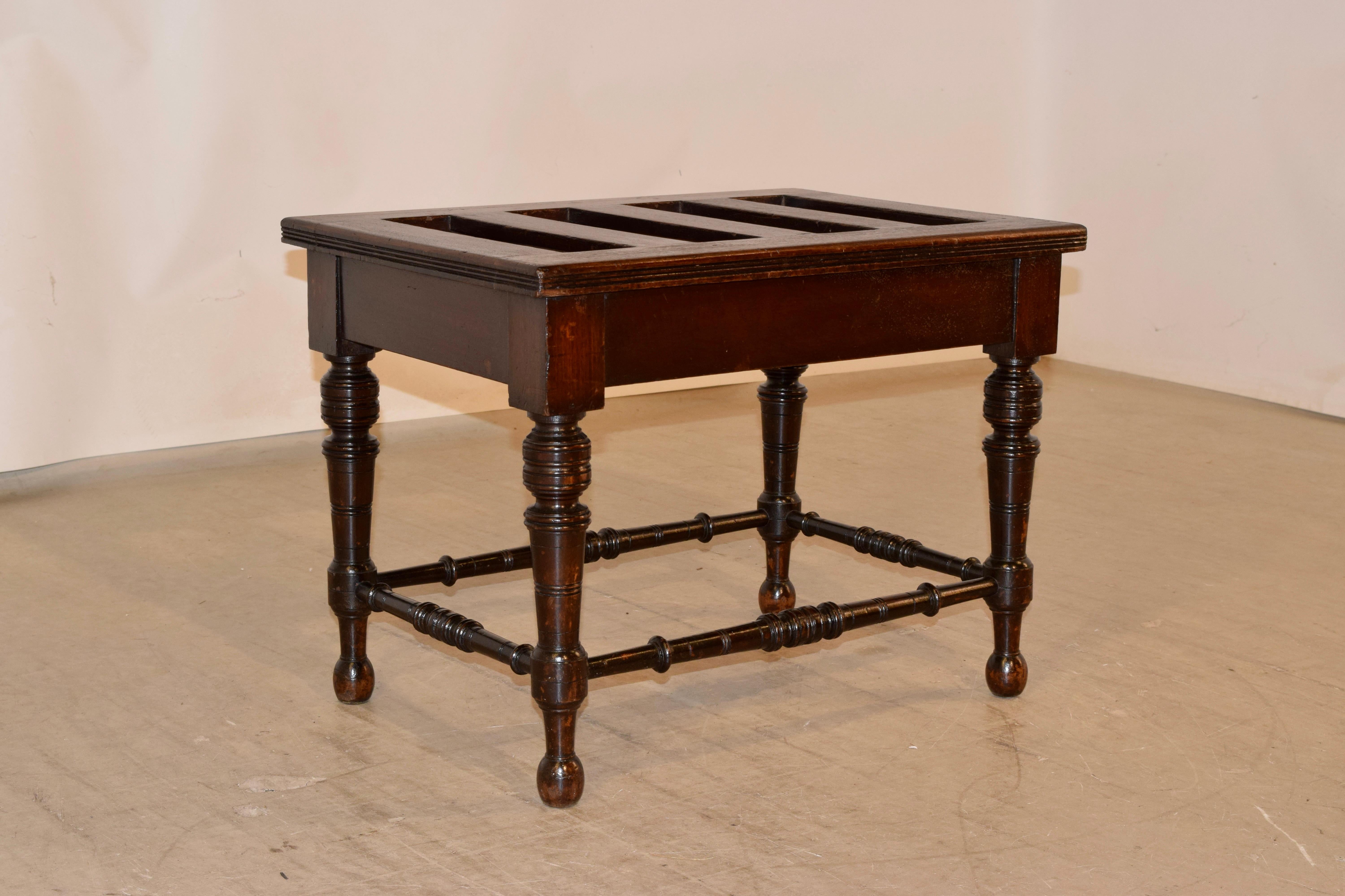 19th century mahogany luggage stand from England with a slatted top with a routed edge, following down to a simple apron and supported on hand turned legs, joined by hand turned stretchers.