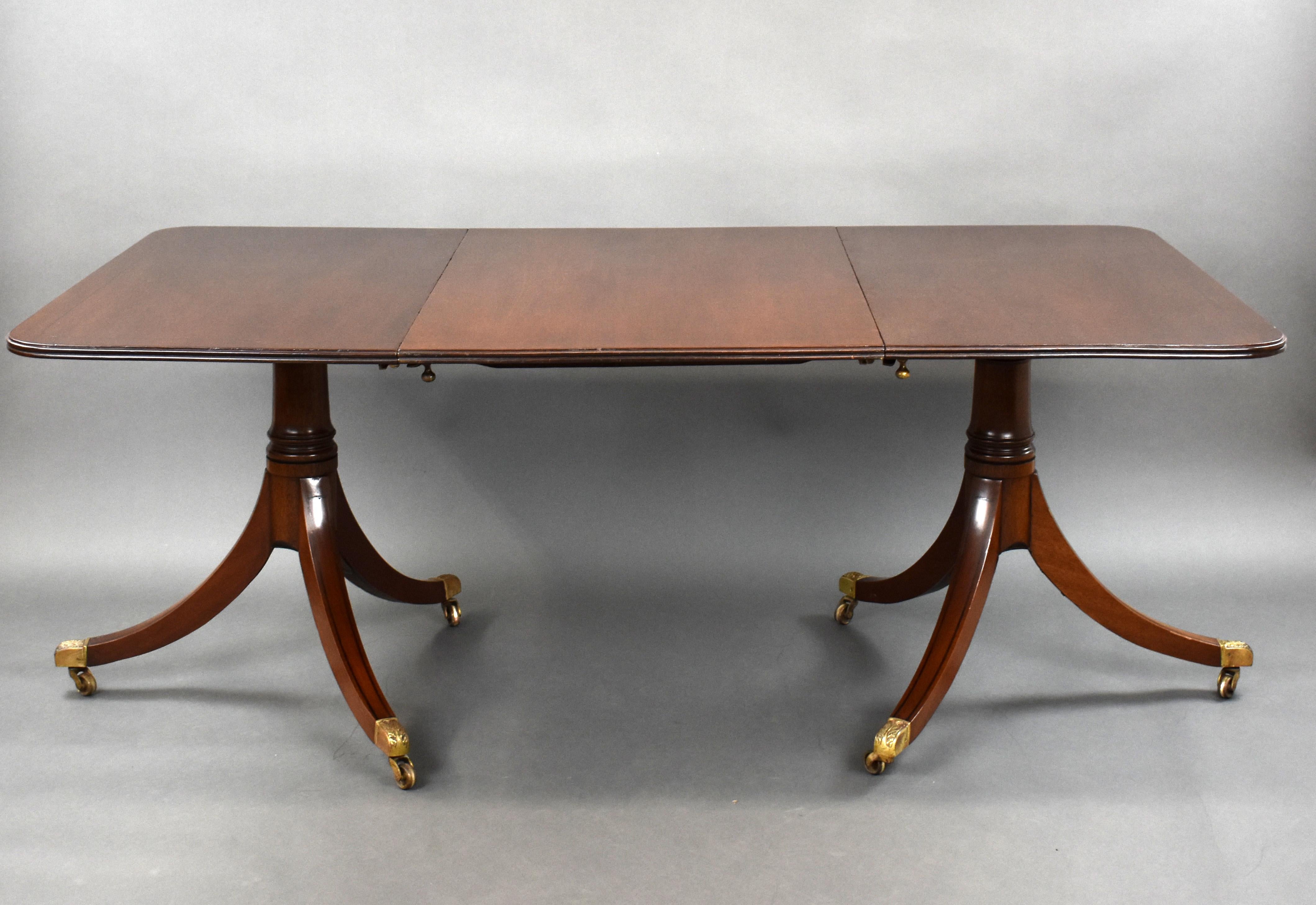For sale is a good quality 19th century mahogany pedestal dining table. The top inlaid with black line having an additional leaf, above two pedestal bases with splayed legs, black line inlays terminating on brass castors. The table is in very good