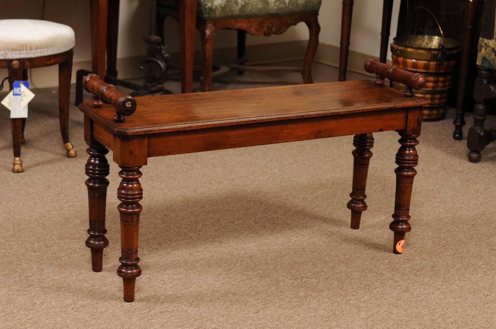 The Regency style hall bench in mahogany with handles and turned legs.