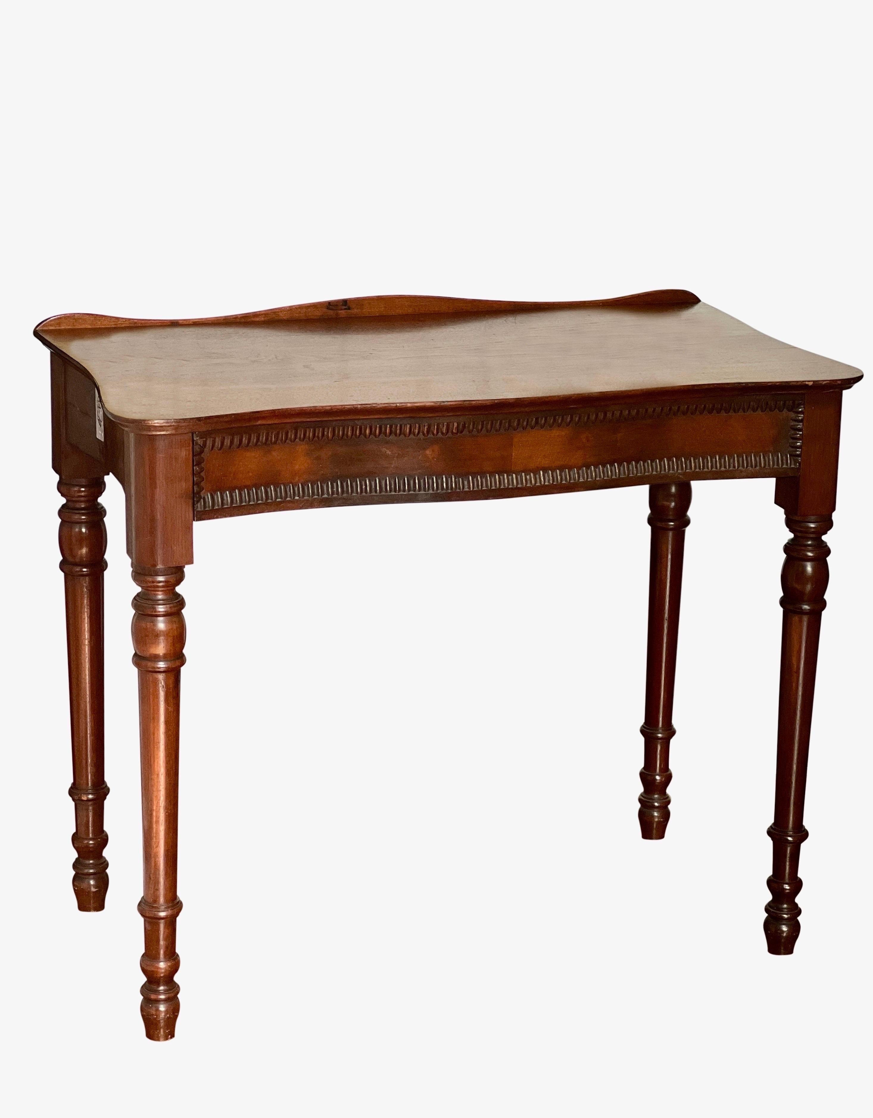 English petite mahogany and cherry wood writing desk, England, 1890's.

Exquisite serpentine desk with gracefully curved front and sides on turned spindle legs. The top has a unique feature as it is able to adjustably swivel to a 90 degree angle on