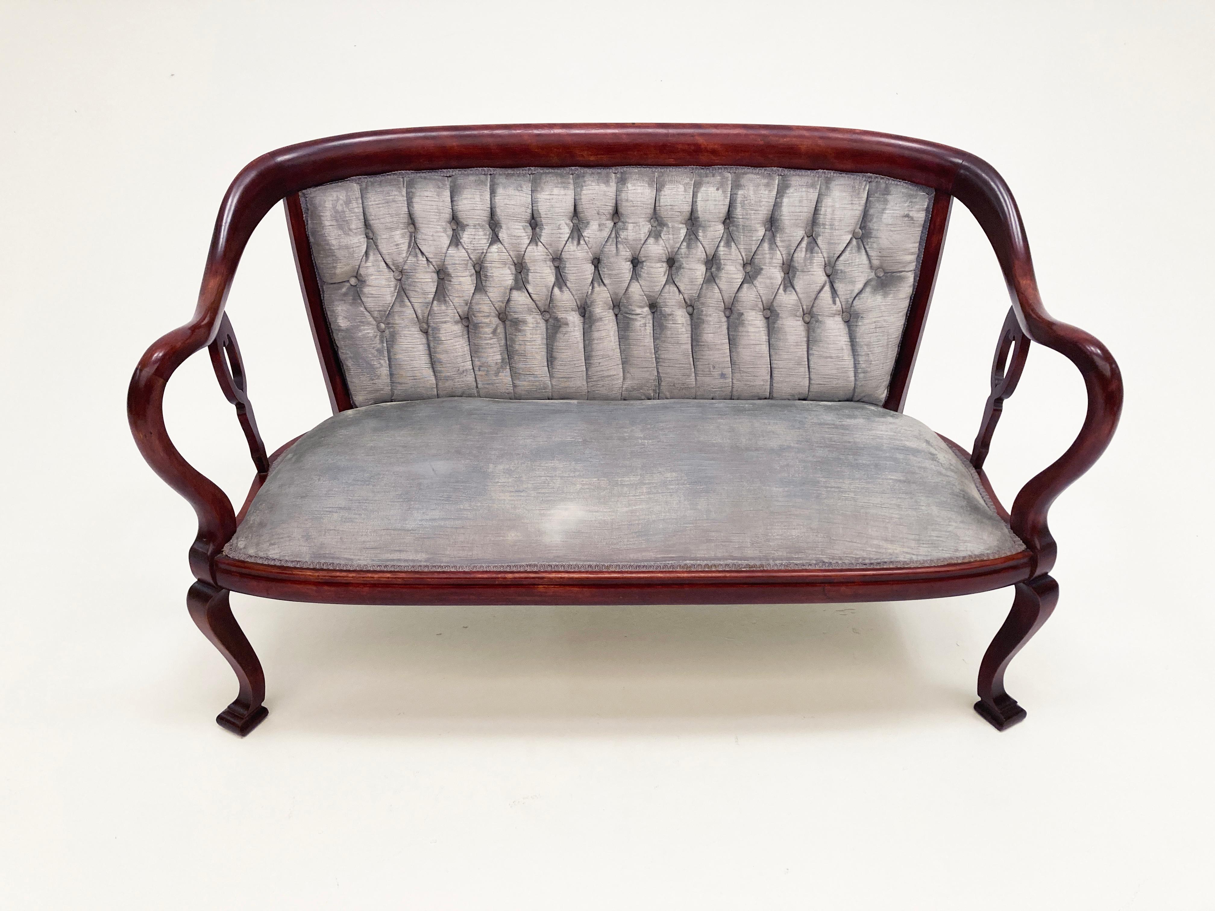 This elegant Georgian style trio is English made, done in a rich mahogany with beautiful curves in the design of the arms and back. The settee is covered in what appears to be the original velvet placed on the piece at its creation in the late