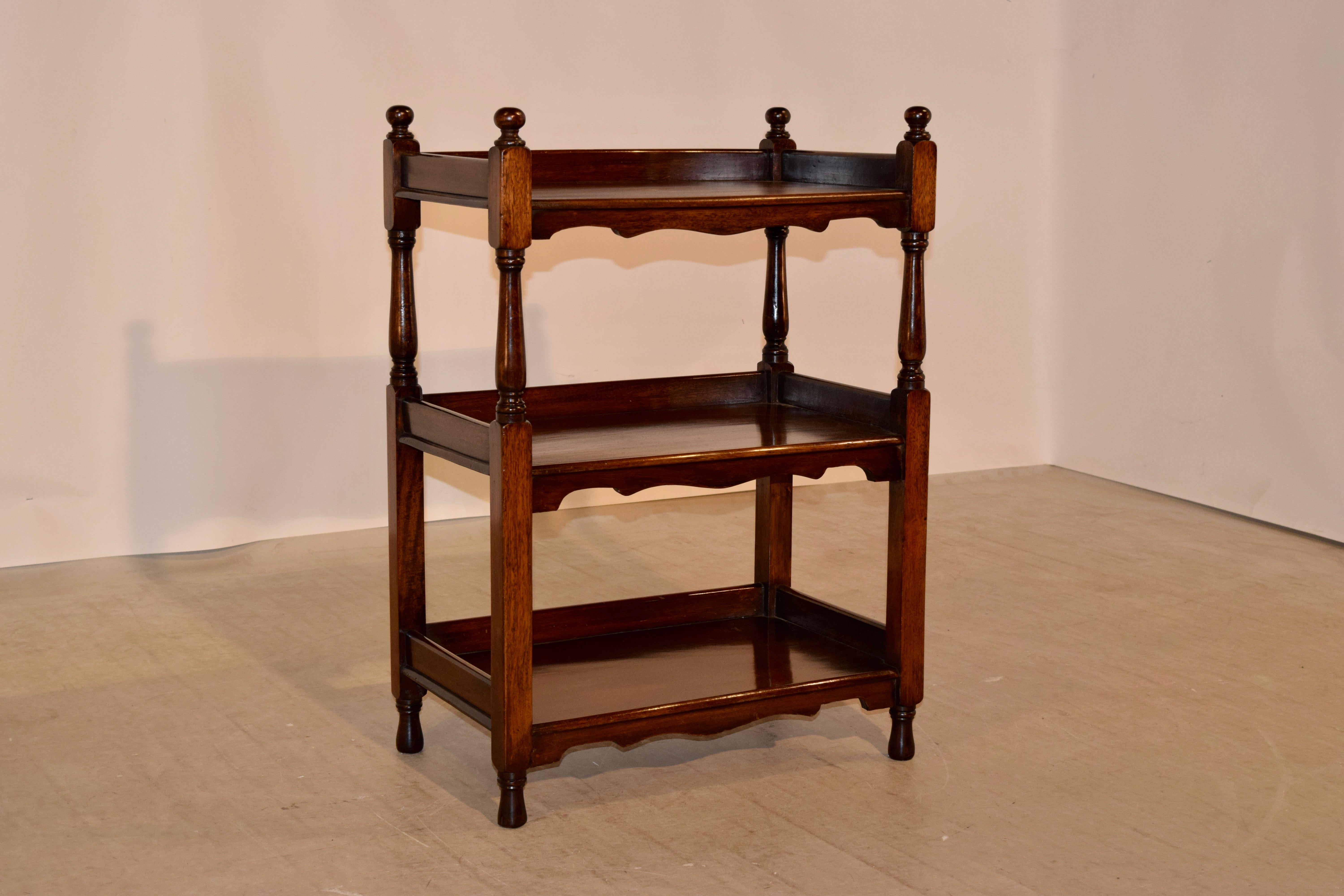 19th century English mahogany shelf with three shelves. The top is decorated with hand-turned finials and follows down to three shelves, all with galleries and hand scalloped aprons on the front of the shelves. Supported on hand-turned feet.