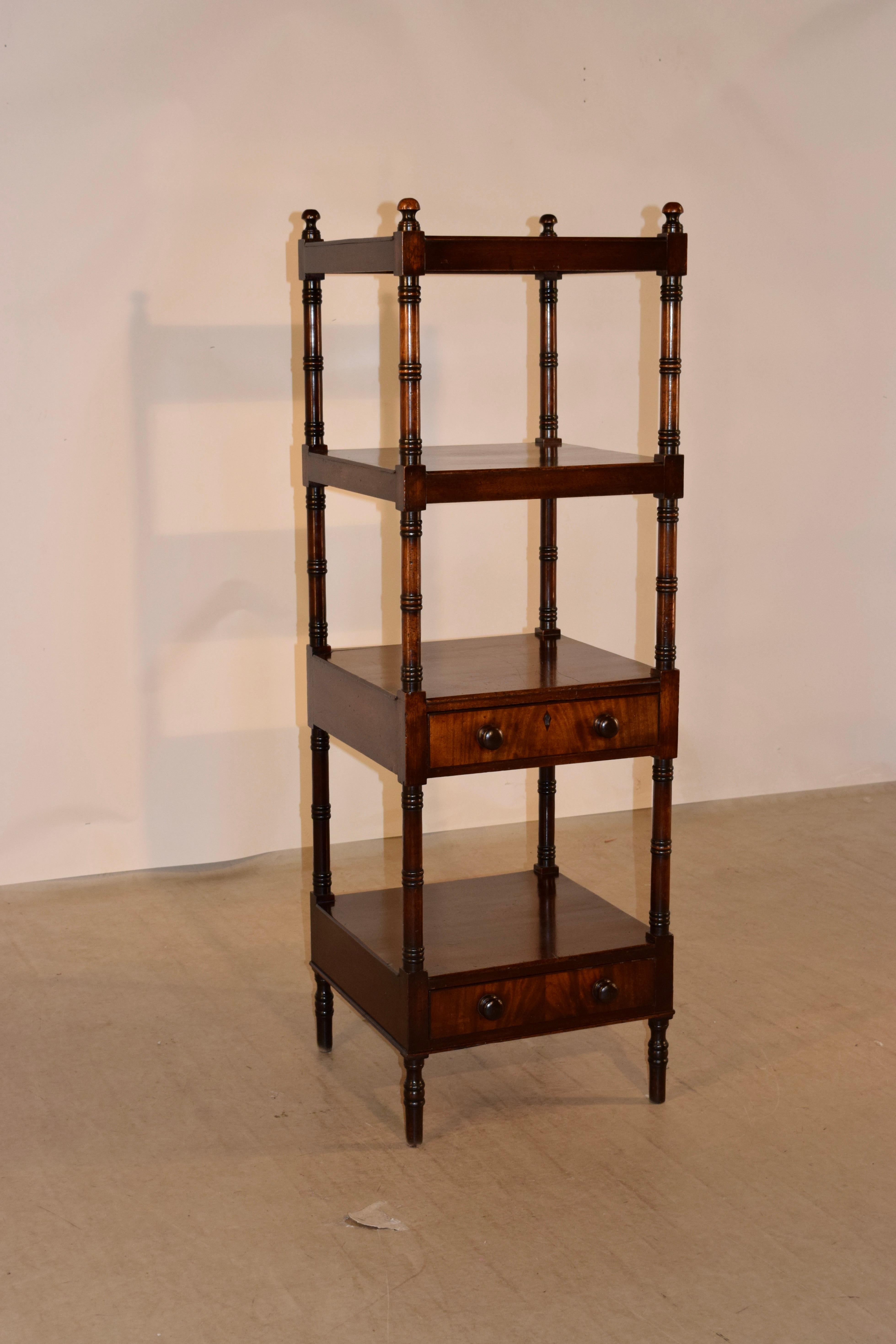 19th century mahogany shelf from England with finials decorating the top and four shelves, all separated by hand turned shelf supports. The two lower shelves have single drawers beneath, which is an unusual feature. The piece is raised on hand