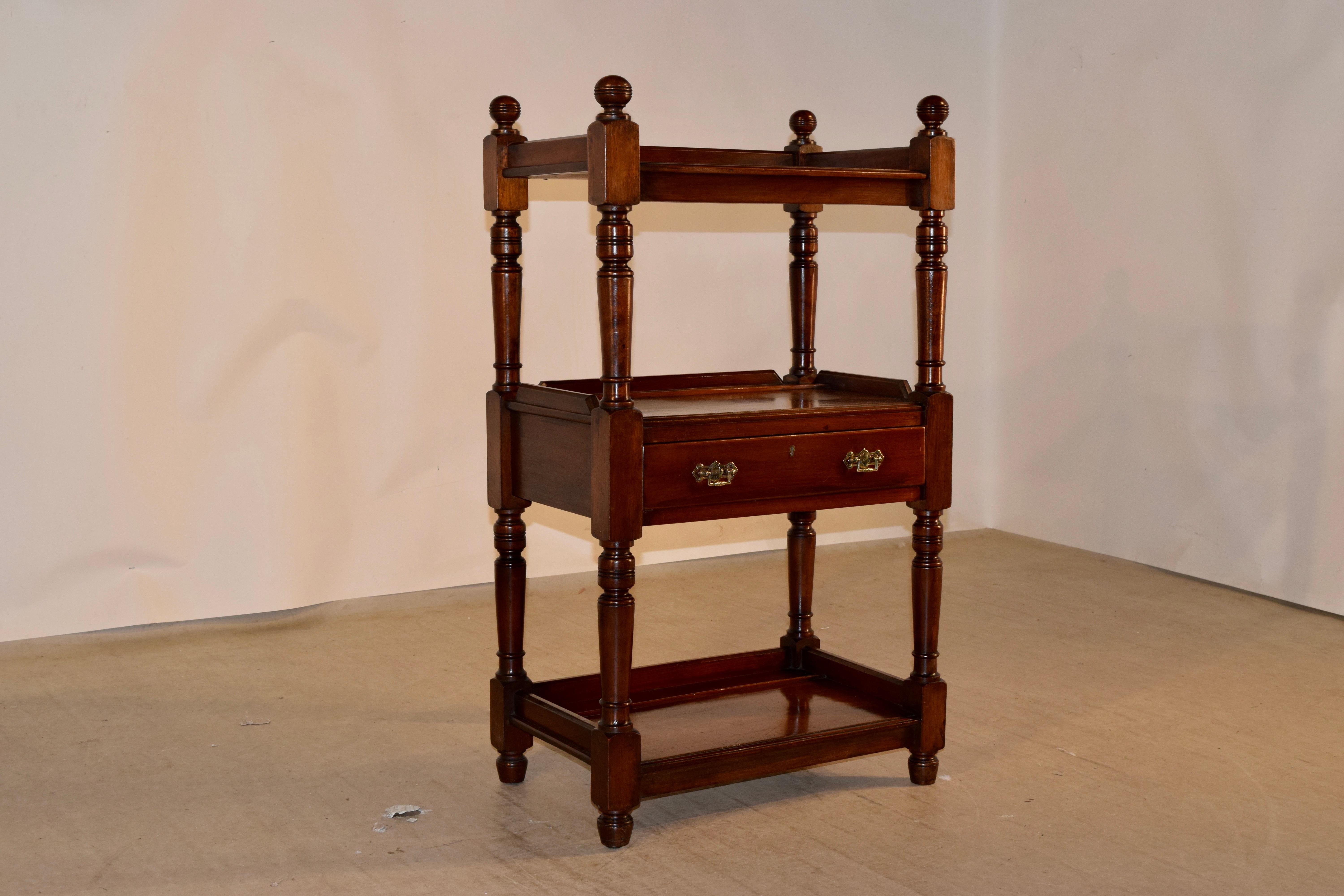 19th century mahogany shelf from England with hand turned finials, following down to three shelves, all with plate rails and galleries around the shelves. The middle shelf has a drawer with what appears to be original hardware. The shelves have hand