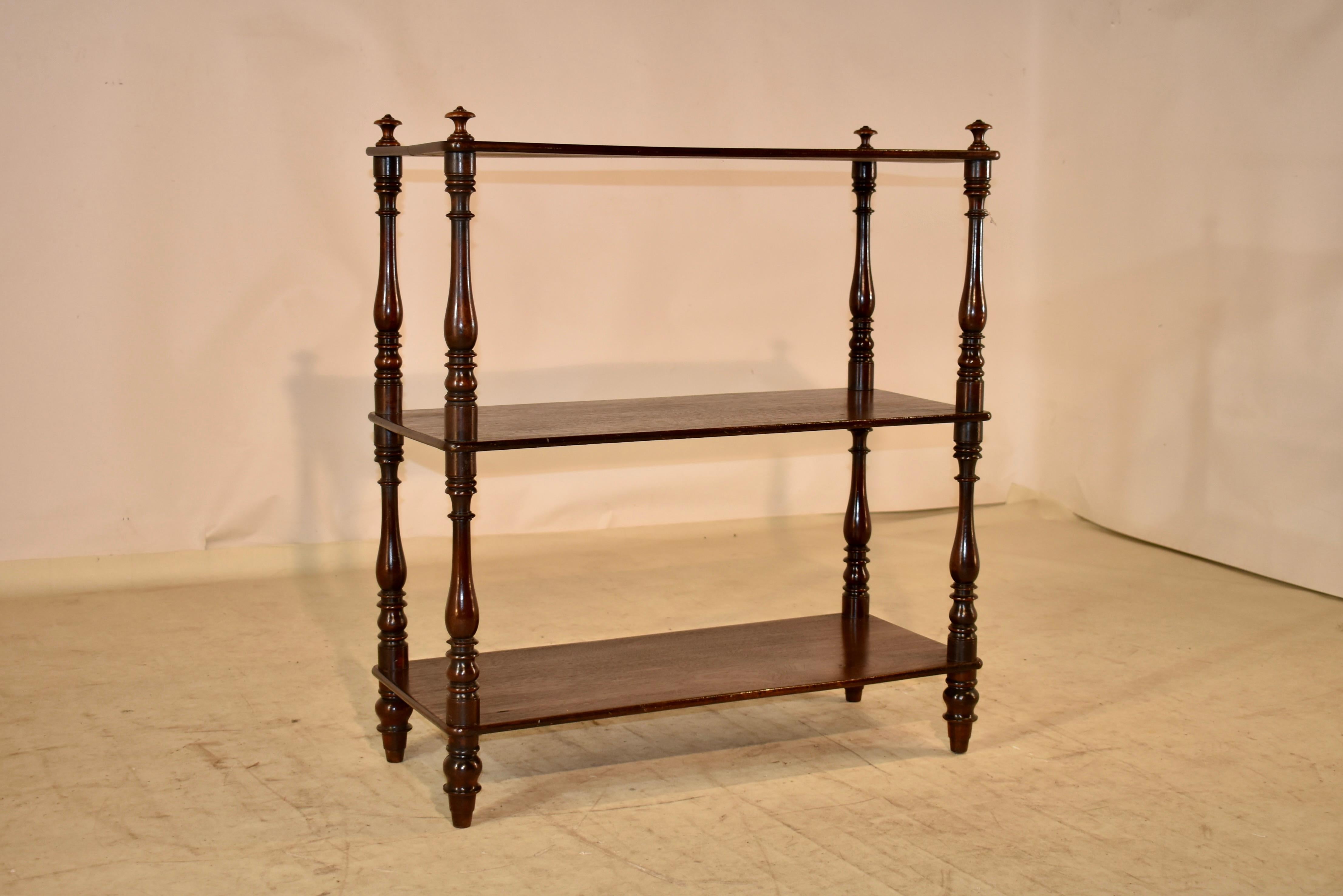 19th century mahogany shelf from England. There are finials on the top of the shelf, over three shelves, all separated by hand turned shelf supports. The feet are hand turned as well and the shelf has an overall rich feel.