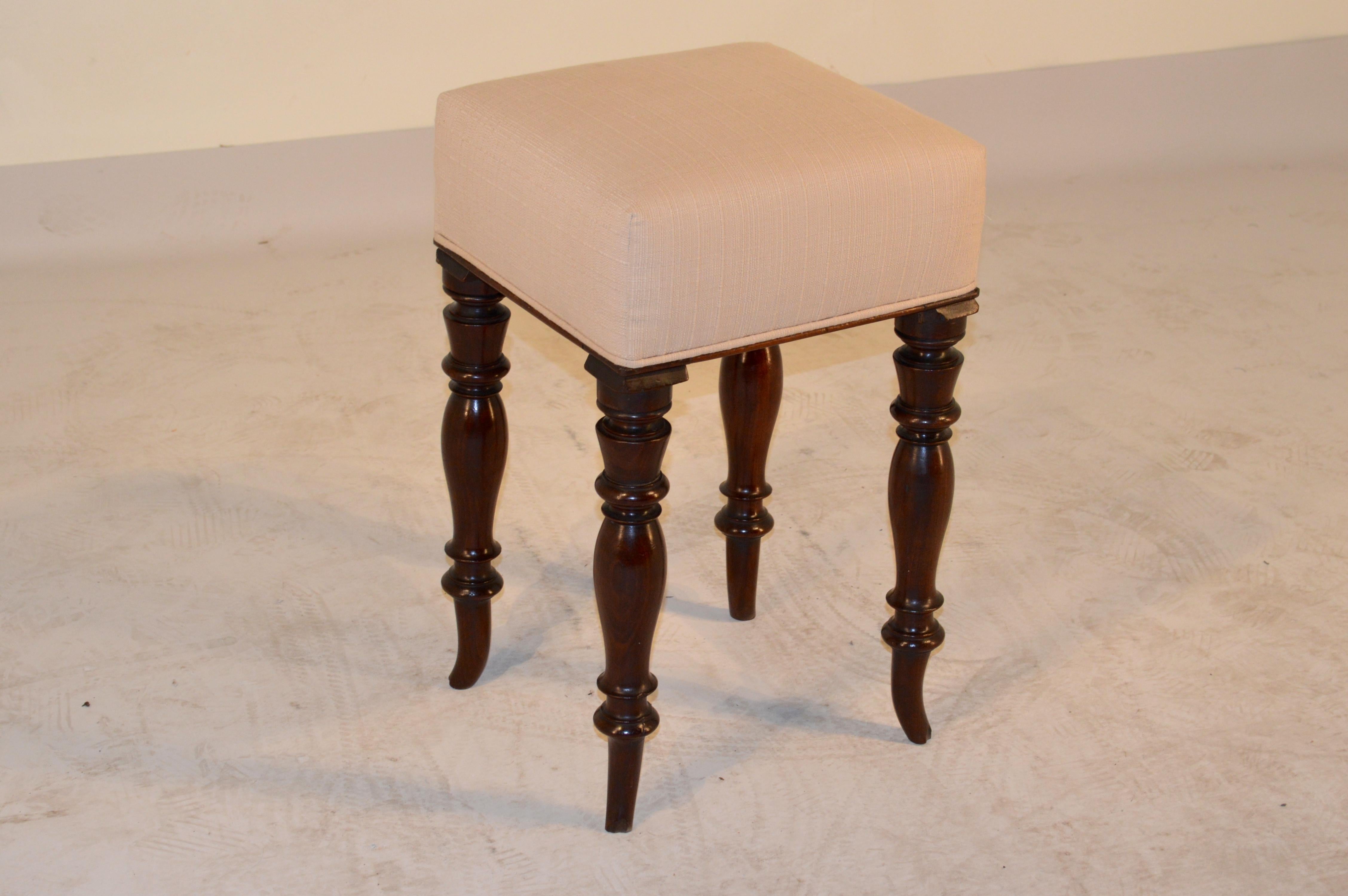 19th century English stool made from mahogany and newly upholstered in linen. Hand-turned legs with nicely splayed feet. Losses to tips of feet and moldings.
 