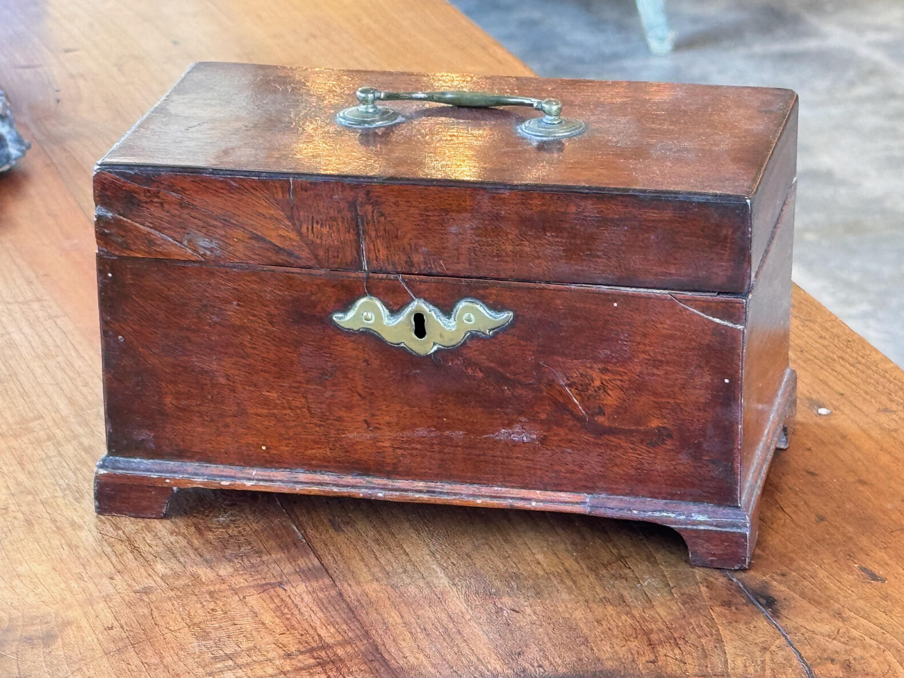 An English tea caddy. It has bracket feet. Made in the 19th Century