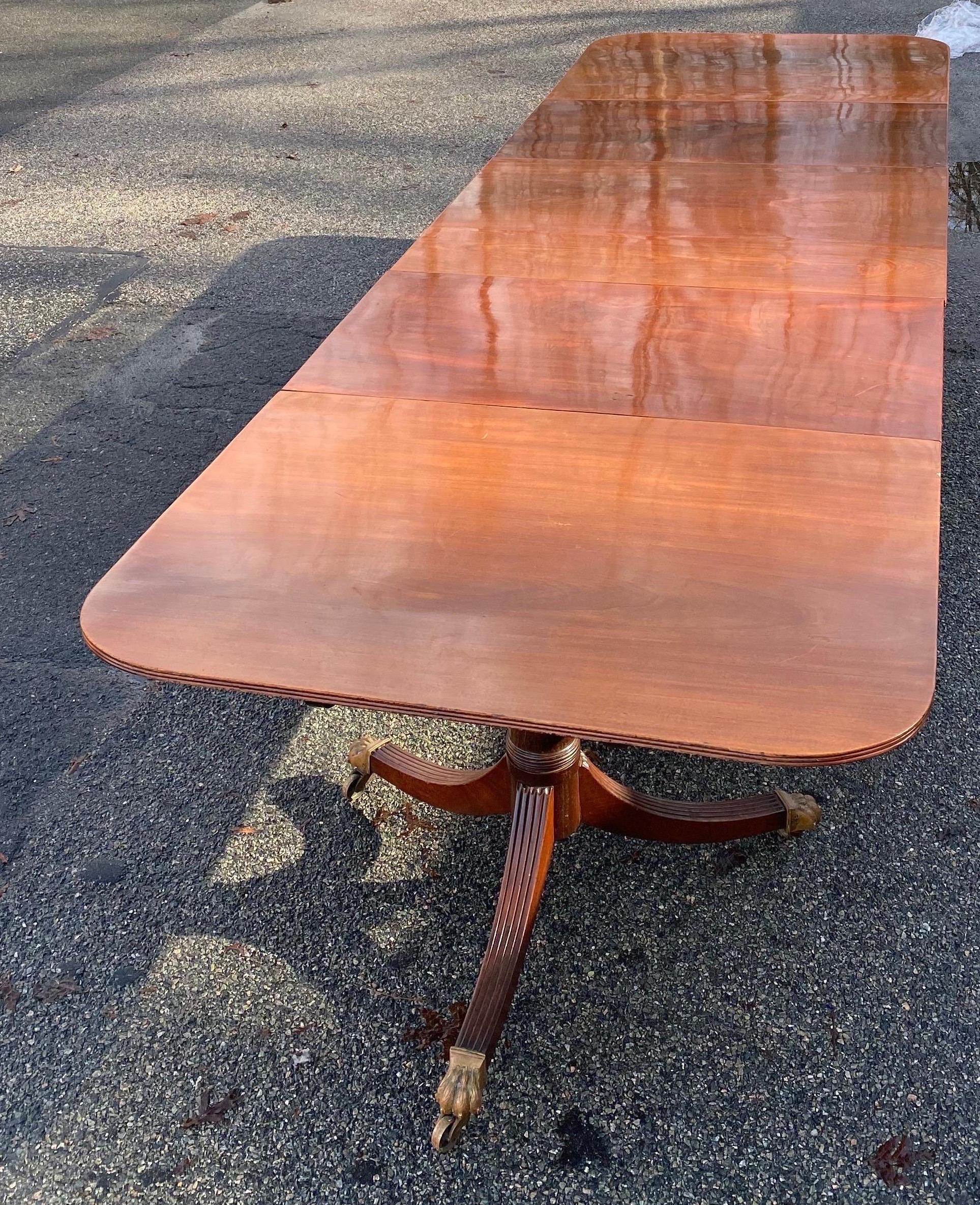 Great quality 19th century English mahogany triple pedestal dining table with harry paw castors. Table consists of three bases, three tops, two leaves extending to 154.5