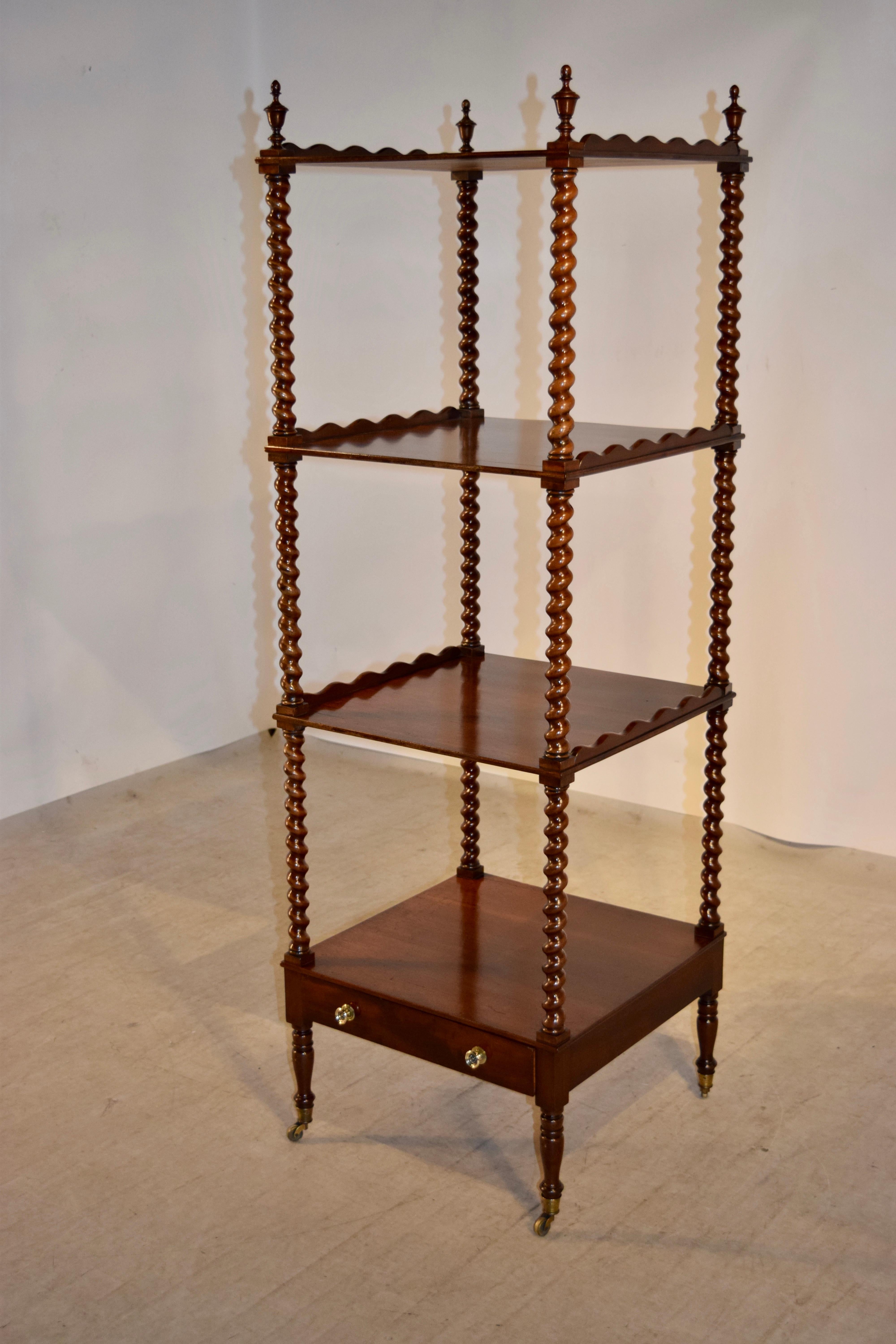 19th century mahogany whatnot from England with four shelves which have scalloped galleries on the sides and are separated by hand turned barley twist shelf supports. There is a single drawer and the piece is raised on hand turned legs with lovely