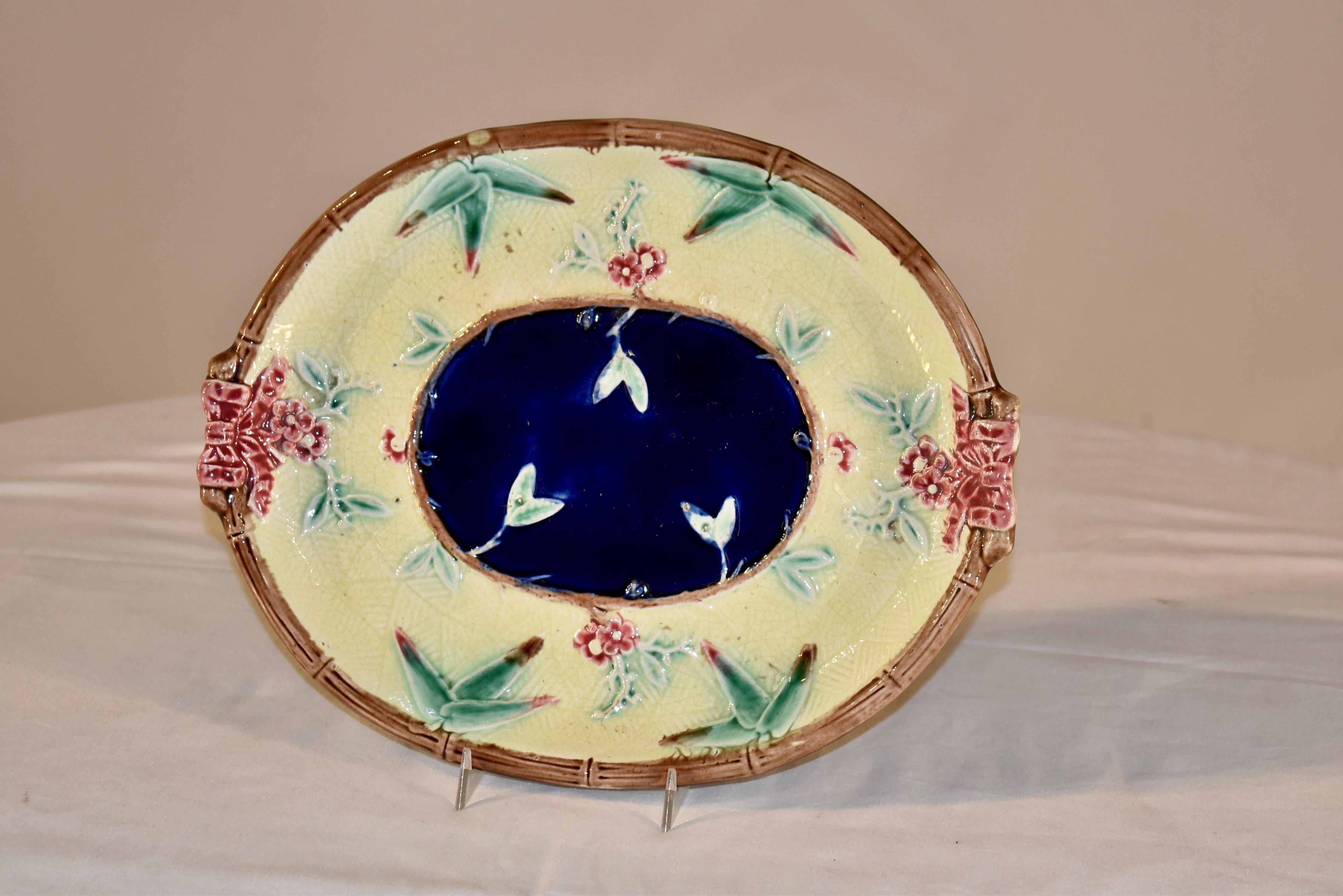 19th century majolica bread tray from England in a lovely color palette. The central medallion is cobalt blue, surrounded by a molded vine and leaf border, surrounded by a gorgeous pale yellow band, also surrounded by a molded bamboo designed edge,