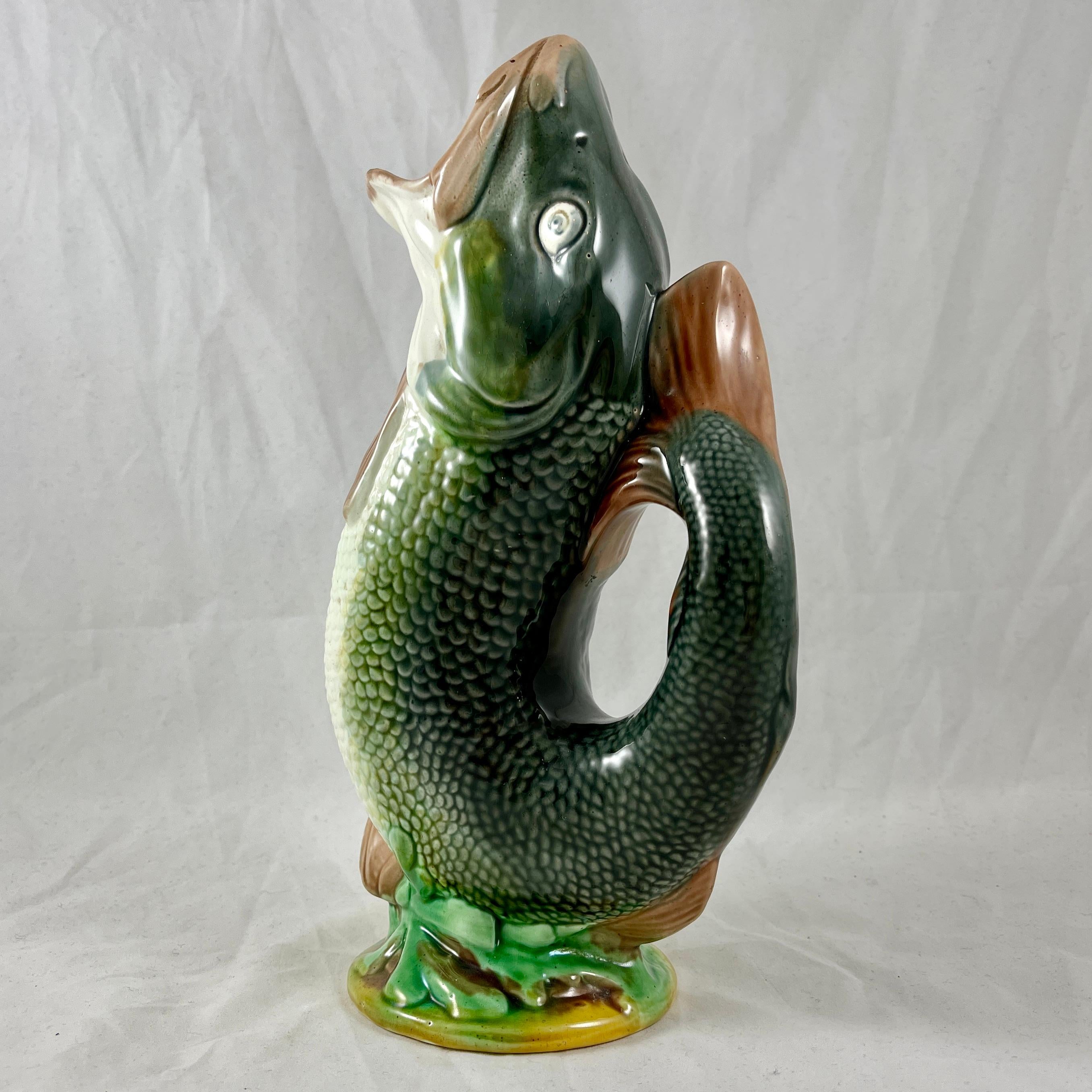 A beautifully glazed English majolica fish jug, maker unknown, circa 1870-1880.

Often called ‘A Gurgler’ for the gurgling sound it produces during pouring, this pitcher is formed as an upright leaping fish, with the tail forming the handle.