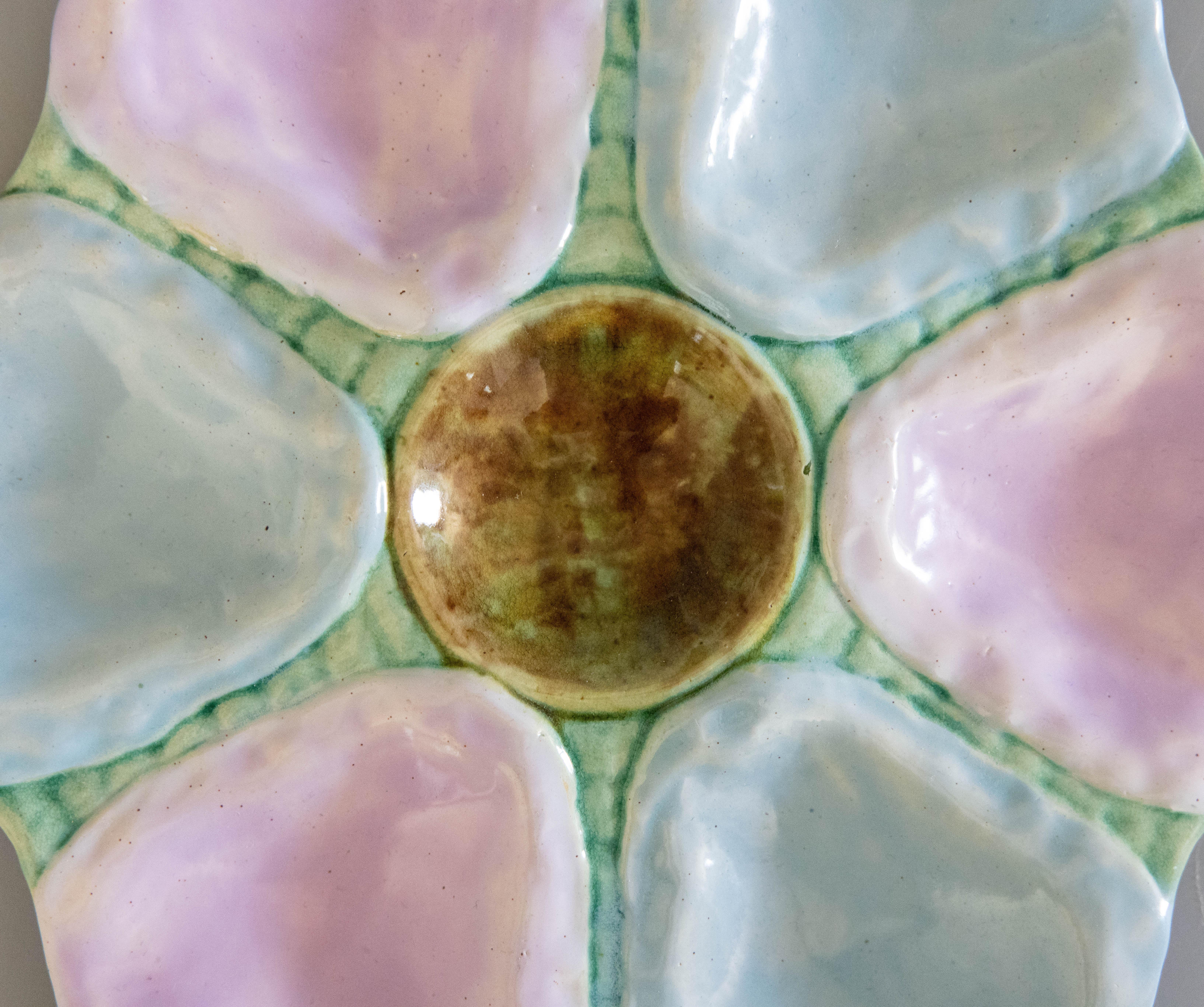 A gorgeous antique 19th-Century English majolica oyster plate, circa 1870-1890. This fine quality oyster plate has six wells with lovely soft shades of turquoise, blue, and lilac pink. It displays beautifully and would also be perfect for serving. I