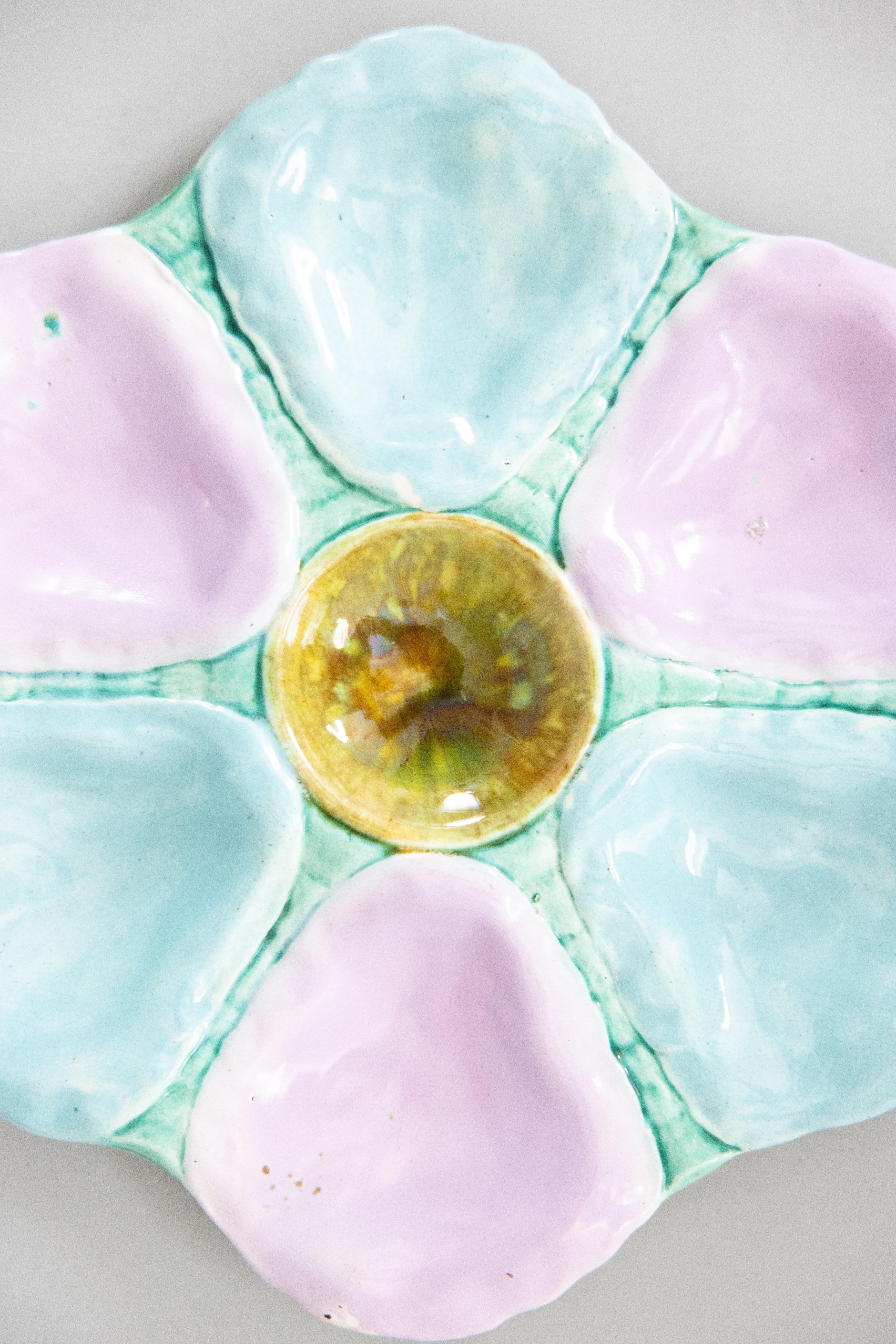 A gorgeous antique 19th-Century English majolica oyster plate, circa 1870-1890. This fine quality oyster plate has six wells with lovely soft shades of turquoise, blue, and lilac. It displays beautifully and would also be perfect for serving. We