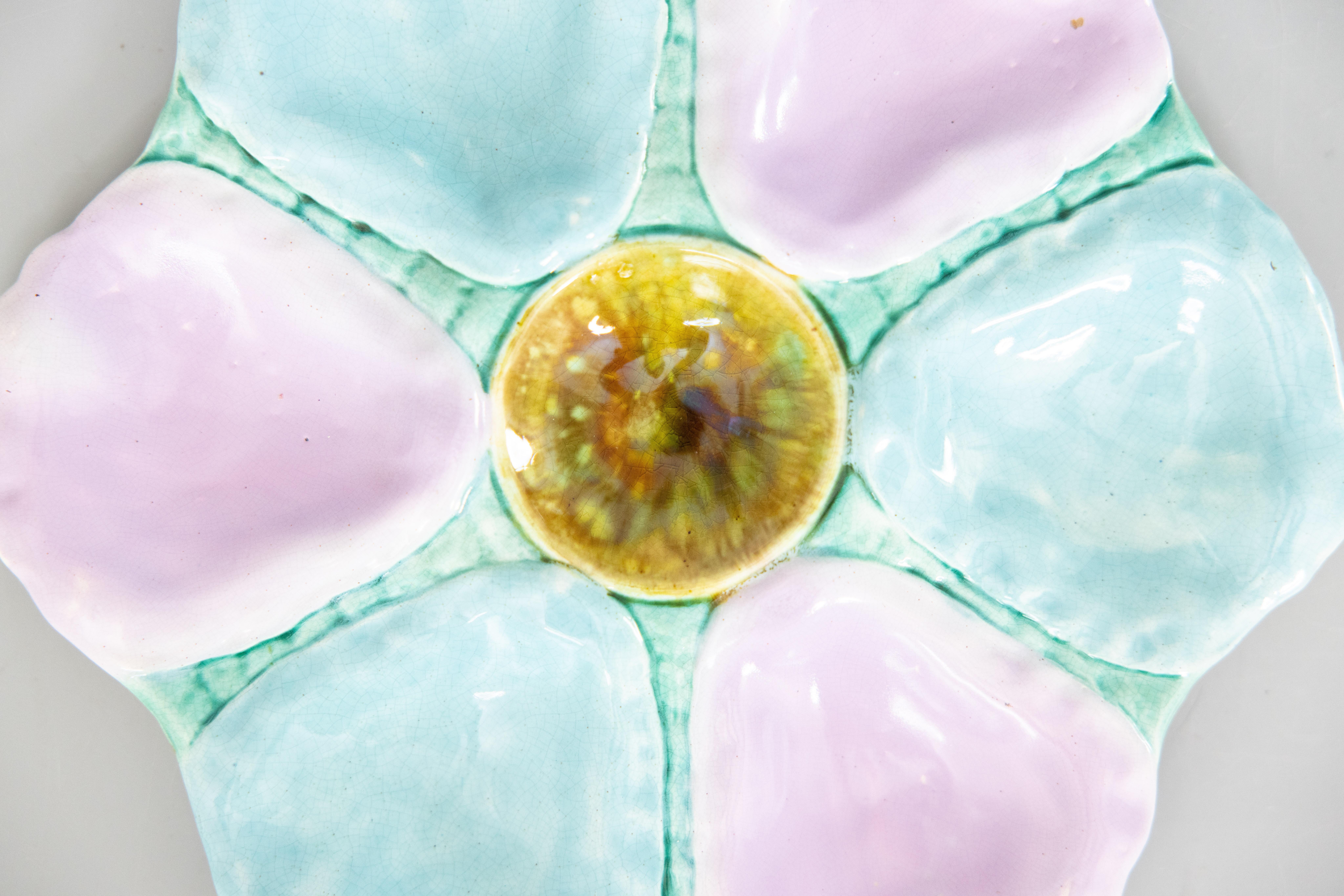 A gorgeous antique 19th-Century English majolica oyster plate, circa 1870-1890. This fine quality oyster plate has six wells with lovely soft shades of turquoise, blue, and lilac. It displays beautifully and would also be perfect for serving. We
