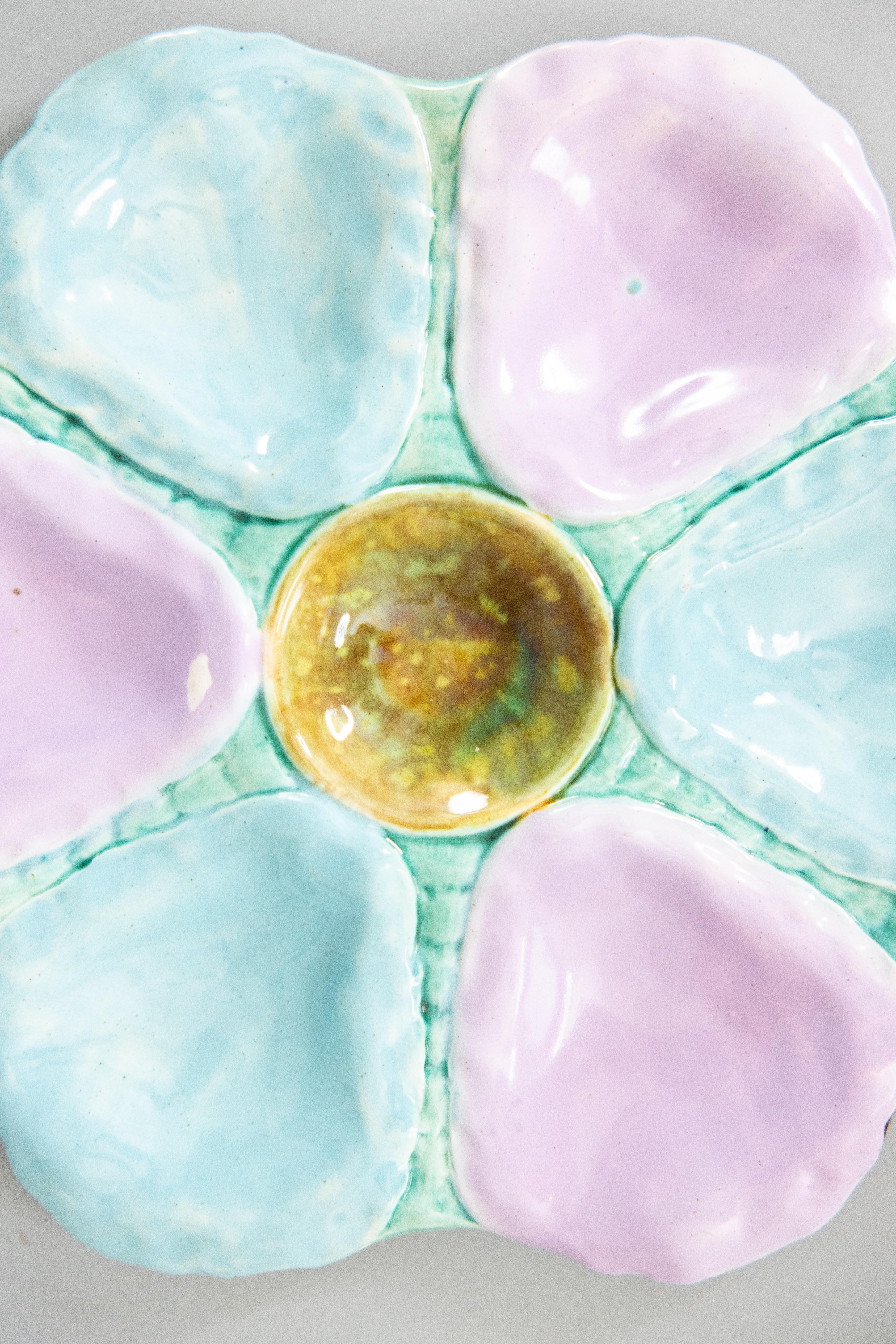 A gorgeous antique 19th-Century English majolica oyster plate, circa 1870-1890. This fine quality oyster plate has six wells with lovely soft shades of turquoise, blue, and lilac. It displays beautifully and would also be perfect for serving. We