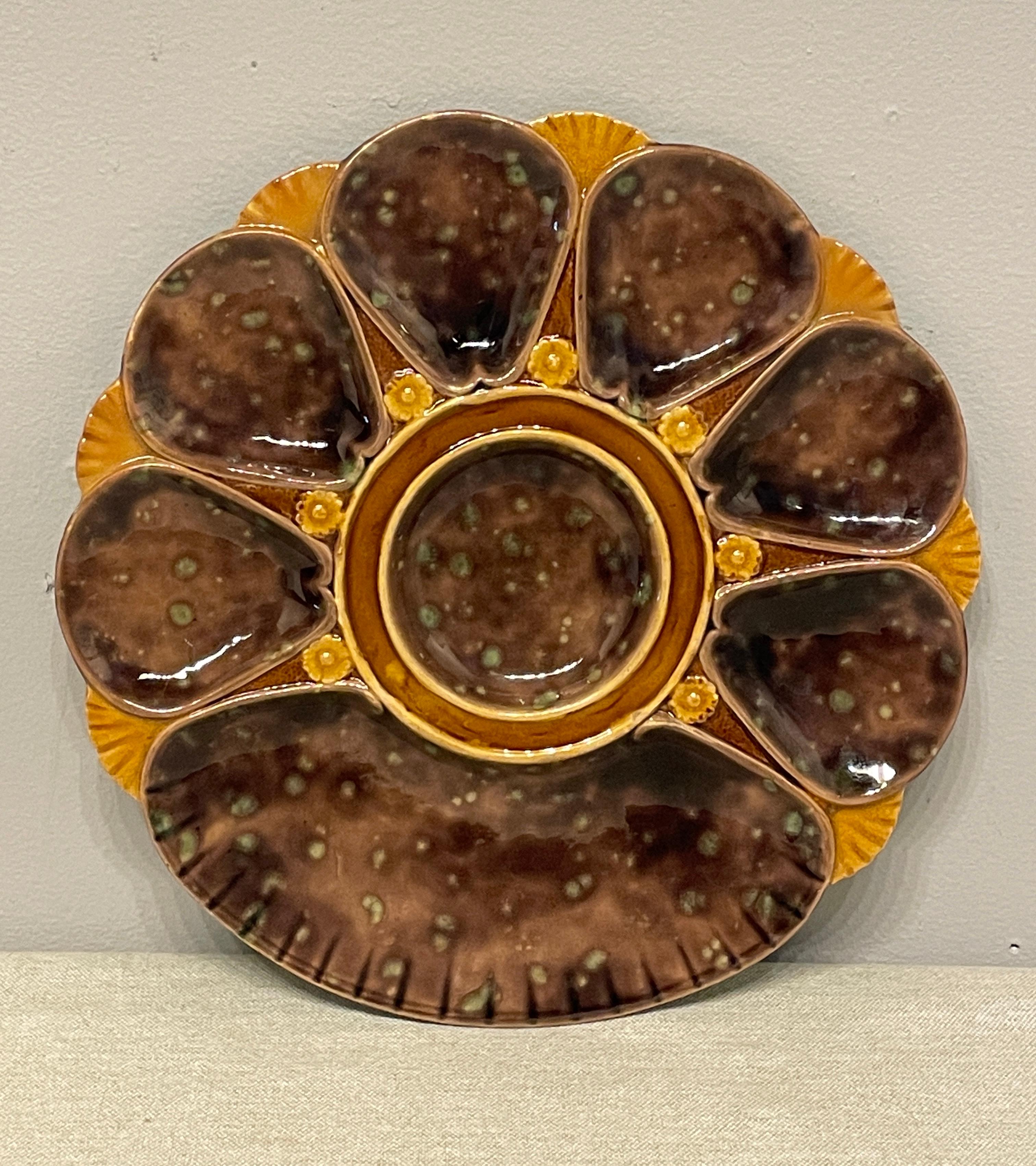 A good 19th century English Majolica oyster plate, unusual brown color, with green back. Marks on the back 2239. 
The plate is in good condition measuring 10