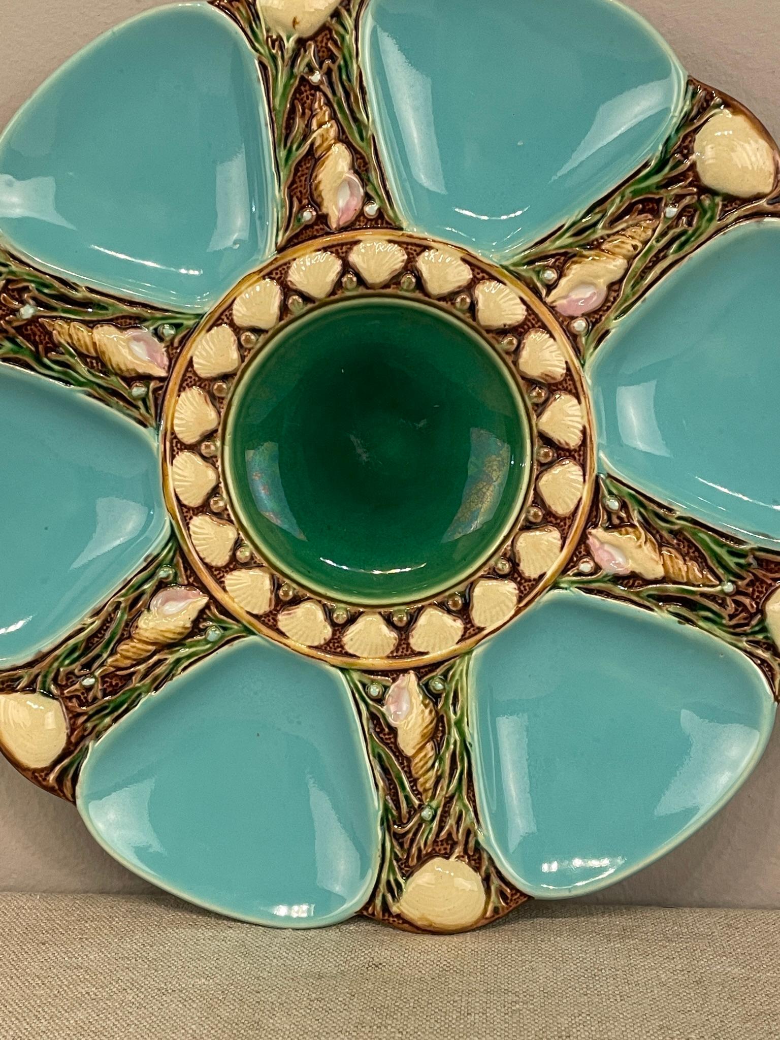 A 19th Century Majolica Turquoise Minton plate, with 6 turquoise oyster well separated with seashells in a relief. With the appropriate marks on the back, stamped 1323, produced by Minton Pottery in England. Dimensions are 9.25 ” diameter and 1”