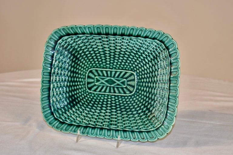 19th century green Majolica tray from England. The tray is in a rectangular shape with an all over basketweave pattern. The edge is scalloped and is in the style of a real wicker basket with a basketweave border. This is a lovely early pressing of