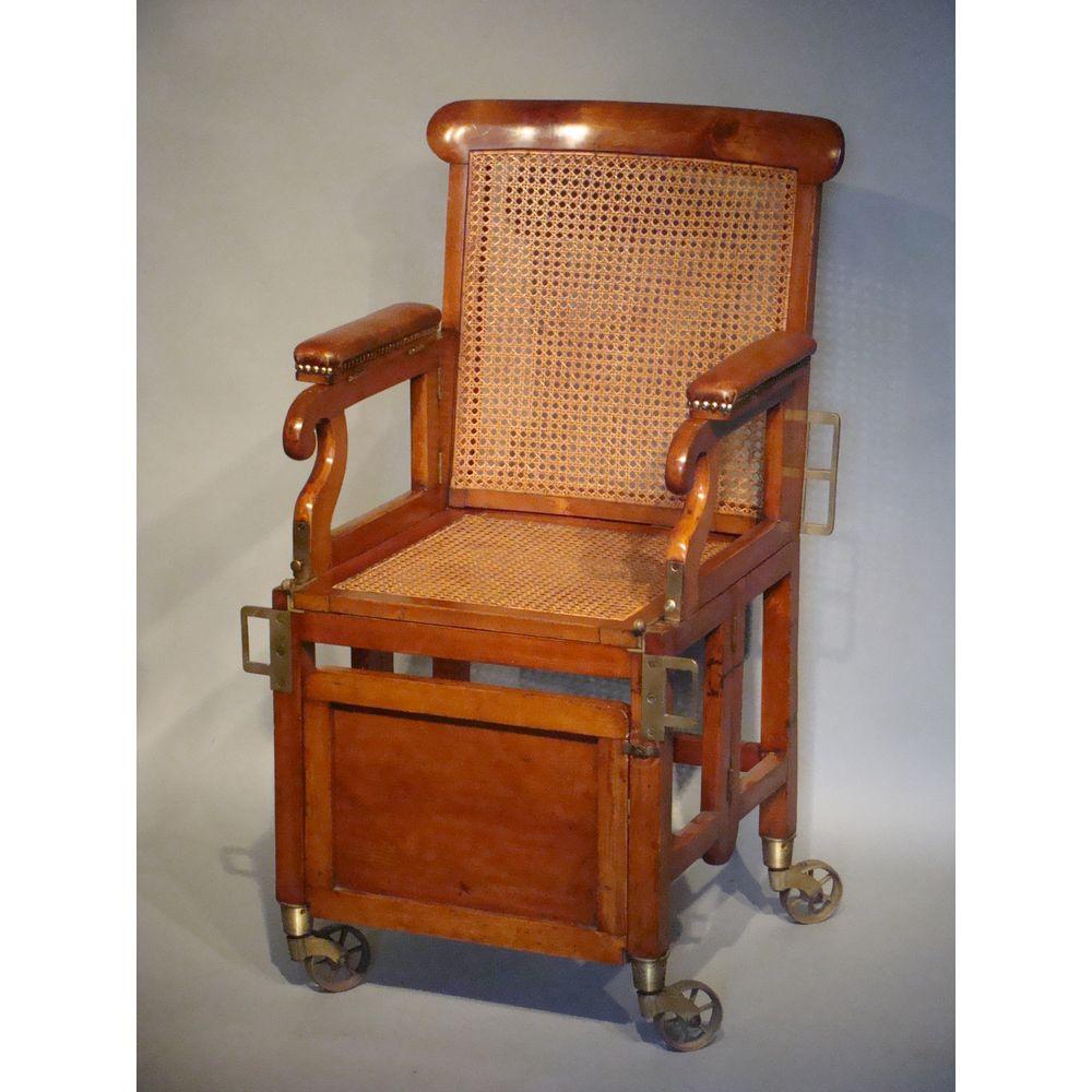 An English mahogany folding military / campaign chair. 
Early-19th century. Late Georgian period, circa 1820-1830.

Retaining its original brass mounts including large scale castors.
Caned, close-nailed seat, and curved back.
With an antique brown