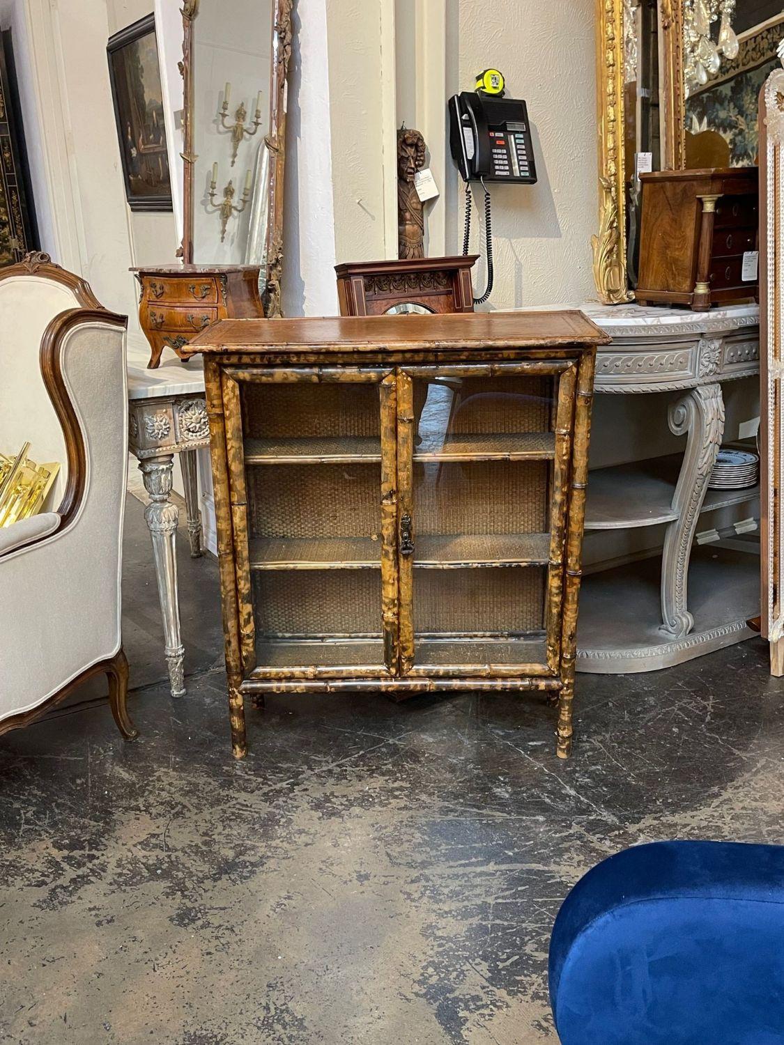 Very nice 19th century English narrow bamboo cabinet with embossed leather. Interesting patina and 3 shelves for storage. A lovely and unique piece!