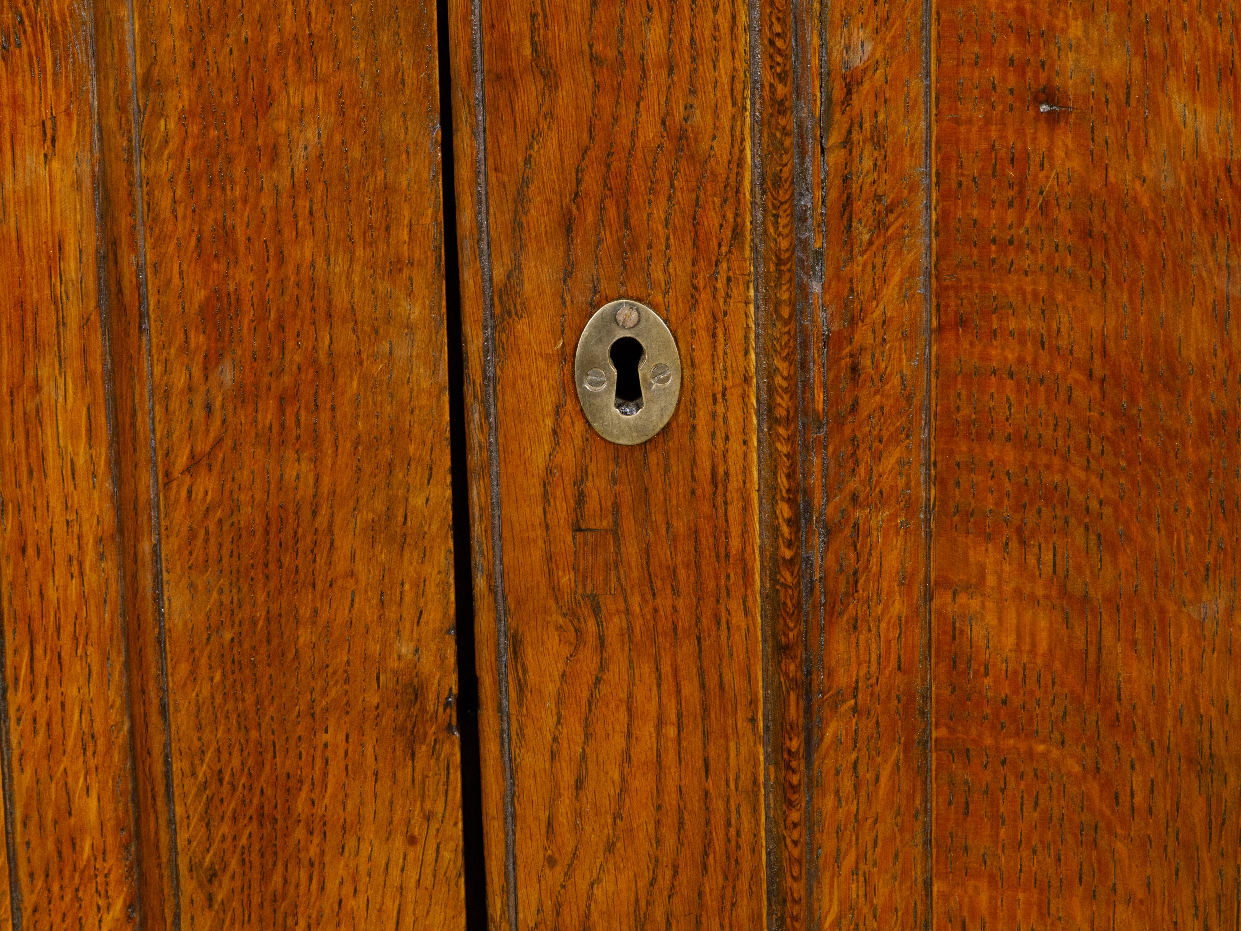 Englischer Eichenholzschrank aus dem 19. Jahrhundert mit geschnitzten Türen, Klammerfüßen und Messingbeschlägen im Angebot 1