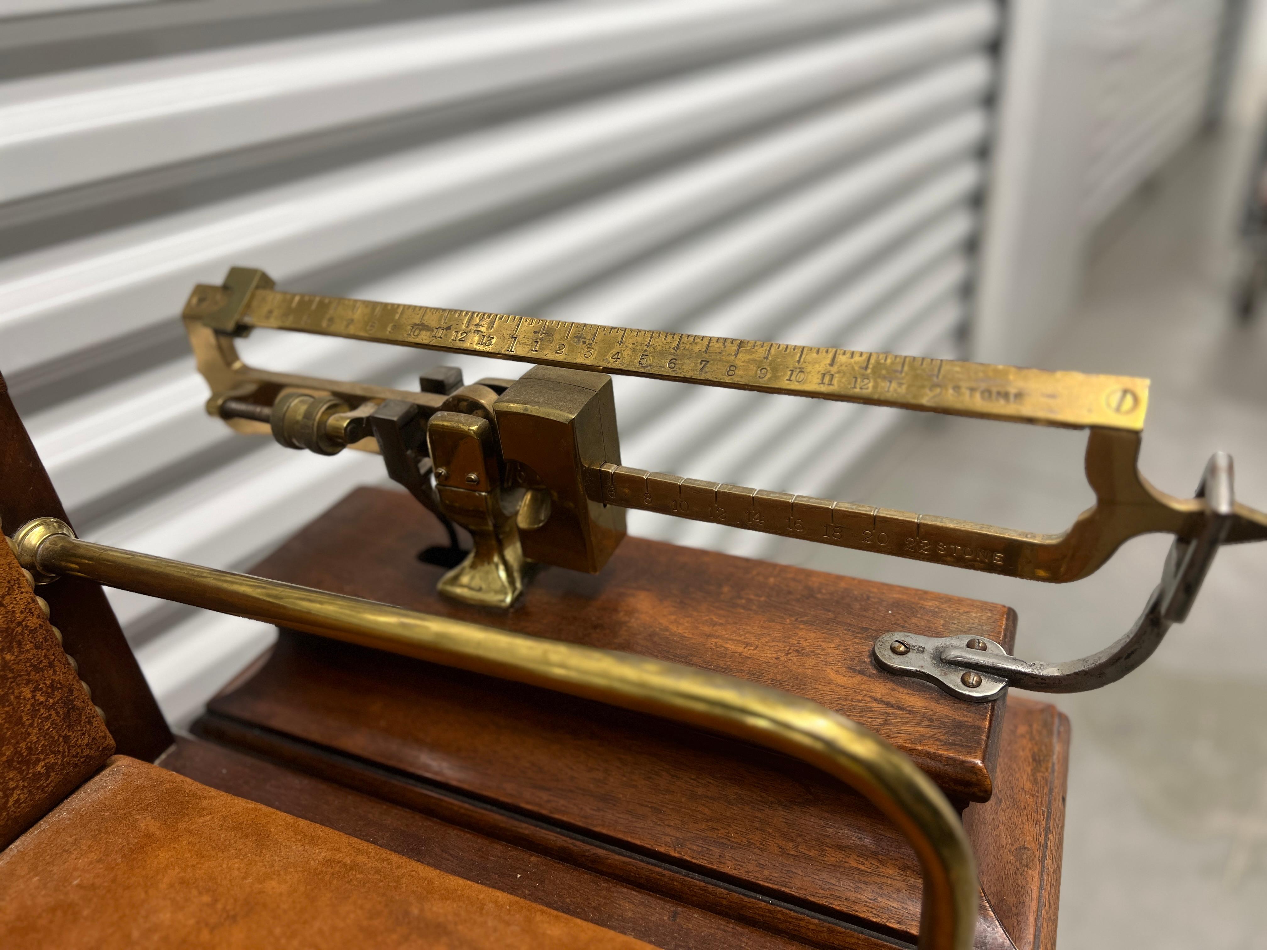 English, 19th century.

A beautiful and rare Jockey Scale chair produced with an oak frame, suede leather upholstery to chair, accented by a pair of brass handrails or arms and nailhead trim. To the side is a great quality brass and iron scale