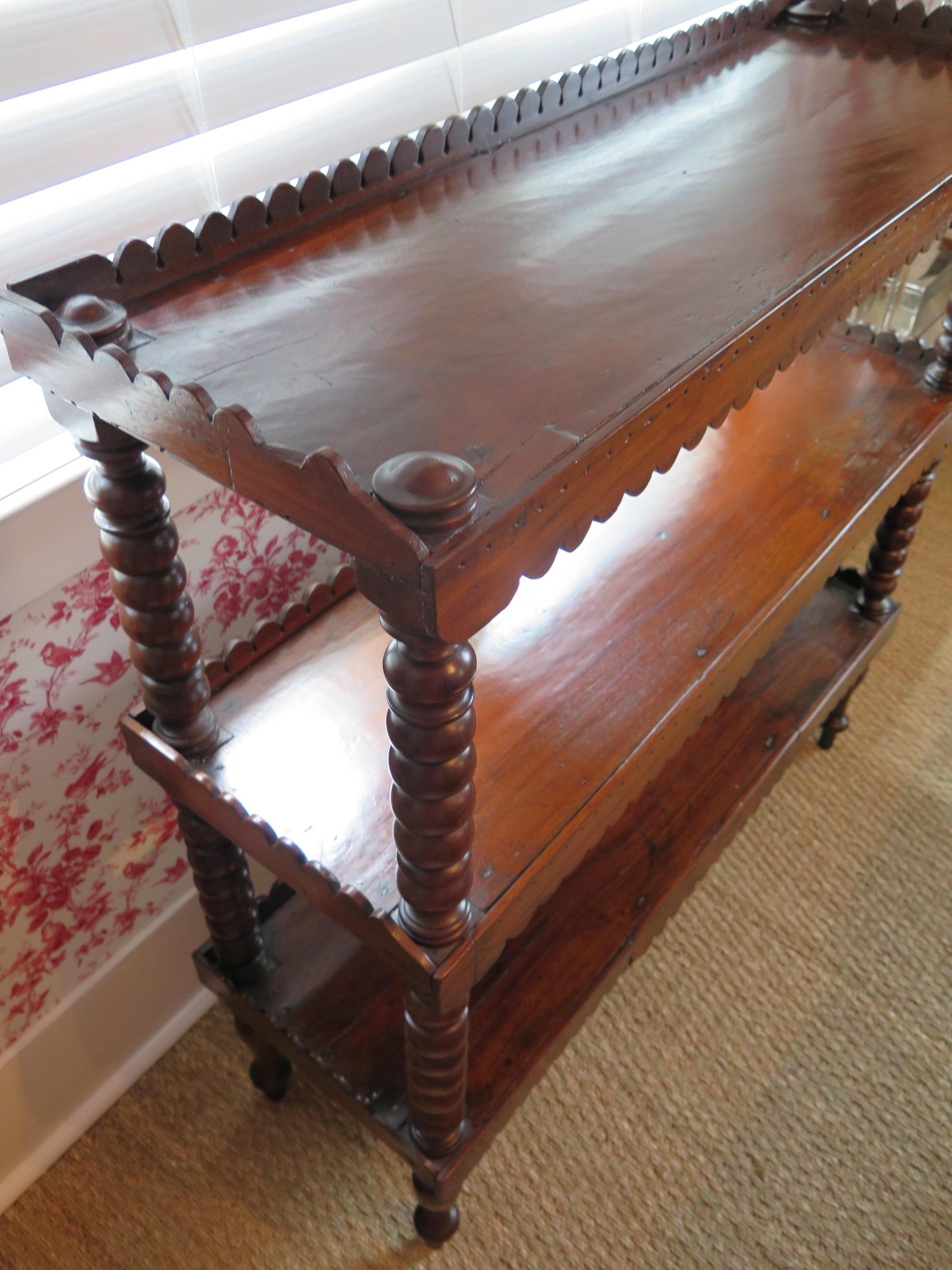 19th century English oak buffet with three shelves and scalloped aprons and hand-turned shelf supports.