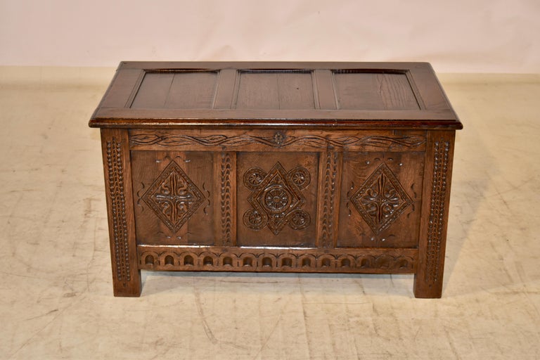 19th century hand carved oak blanket chest from England. The top has three panels, following down to a plain paneled back and sides. The front is the real star of this chest. It has three hand carved panels with geometric patterns, flanked by hand