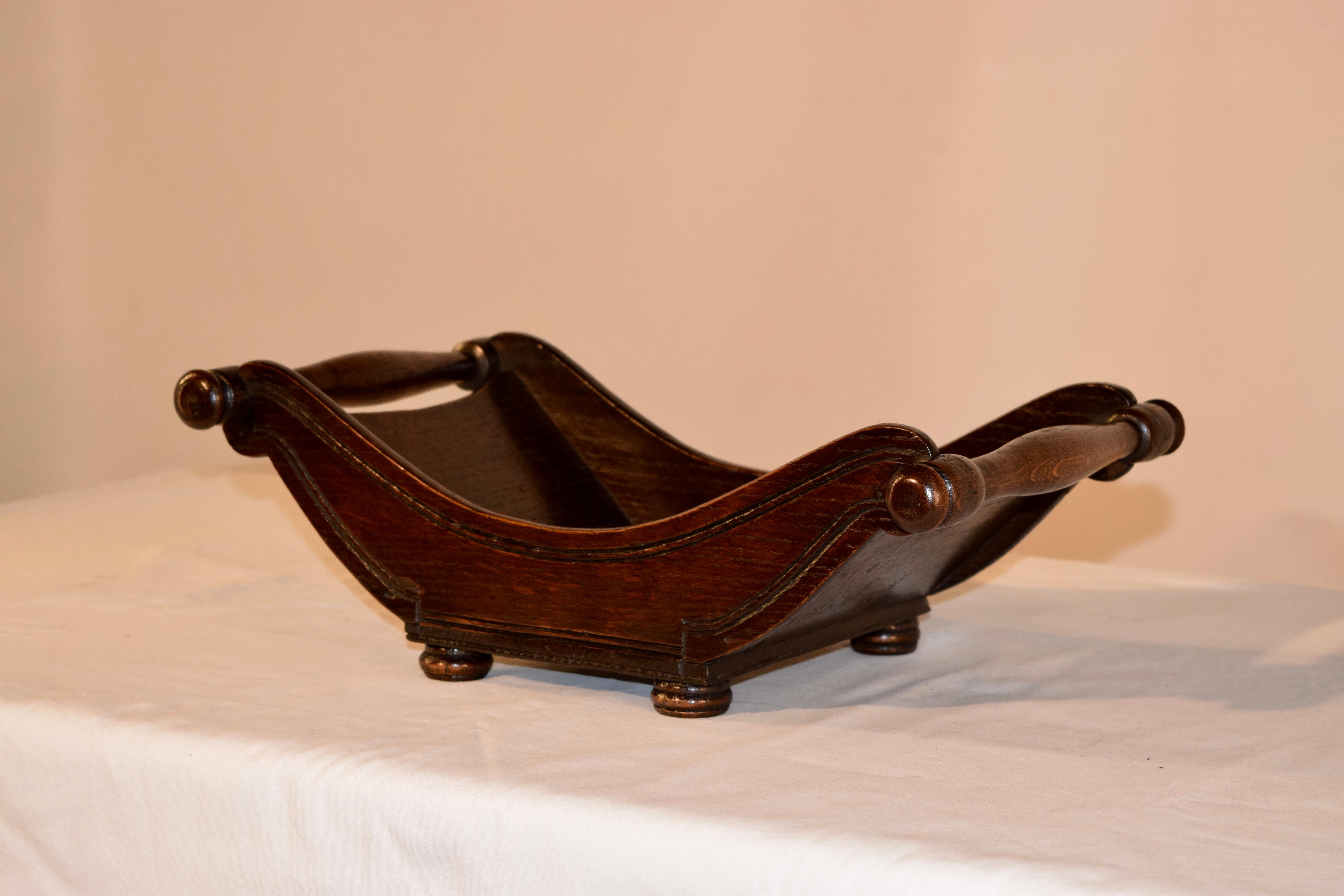19th century English oak cheese cradle with a wonderful sleigh shaped base and hand turned handles with lovely hand turned finials on the ends. Raised on hand turned feet.