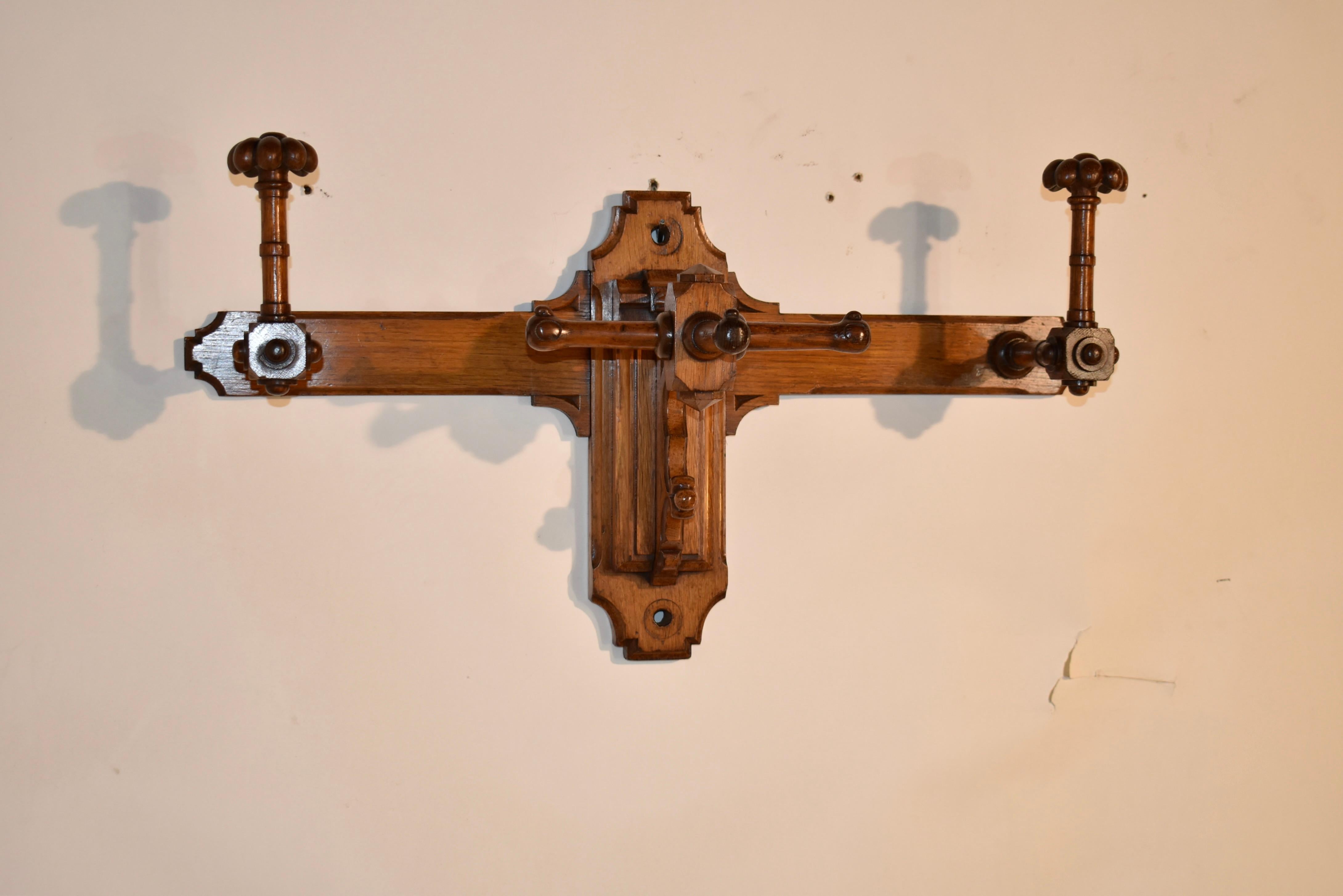 19th century oak coat and hat rack from England.  The piece attaches to the wall, and is handsomely turned and shaped for added design detail to any small space.  The back is shaped , and has hat pegs that extend from the back.  The tops of the pegs
