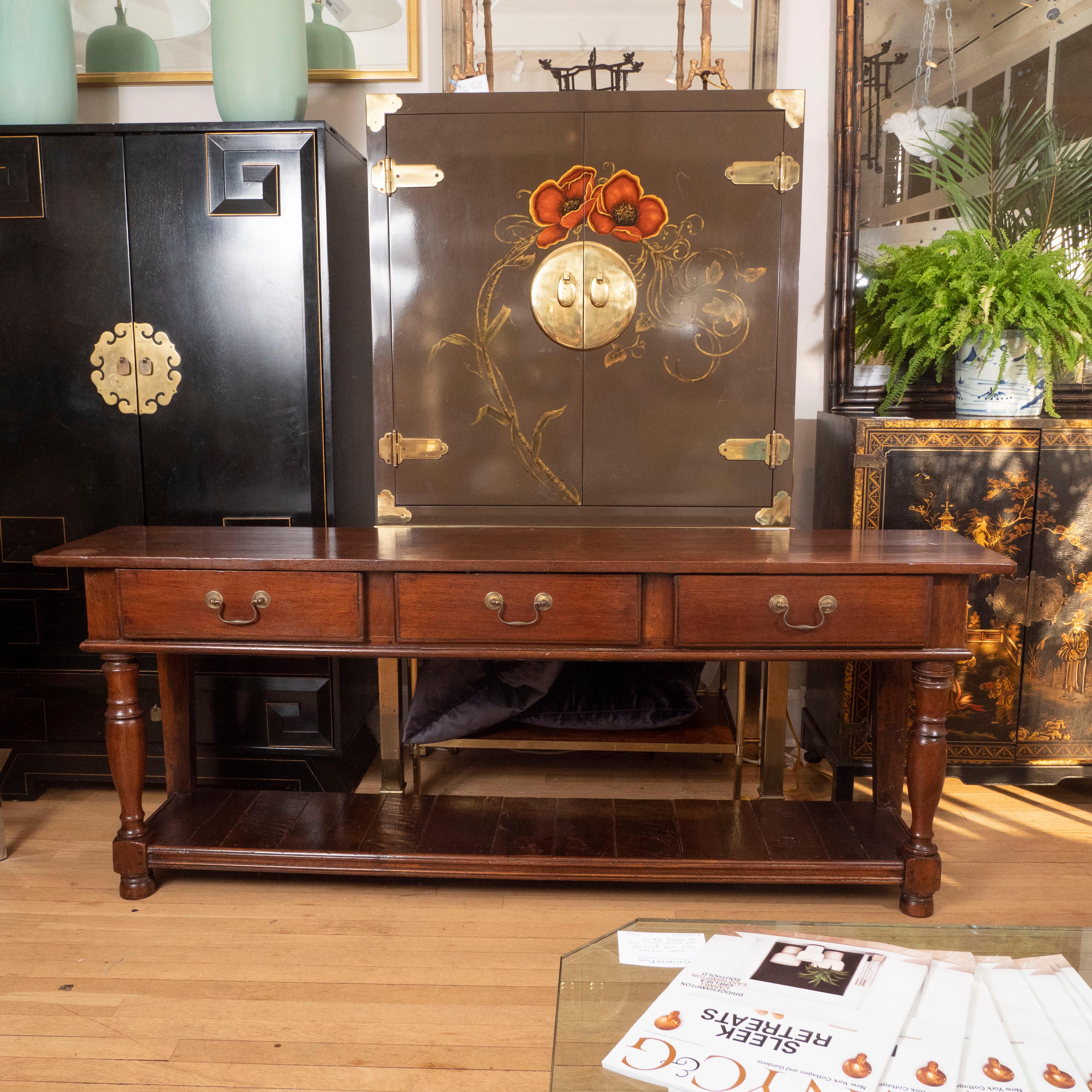 Oozing with character, this long 19th century English oak console/dresser would be perfect in any room. The piece features three drawers with brass pulls, a lower shelf and turned legs. Great as a server, a TV console or behind a sofa.