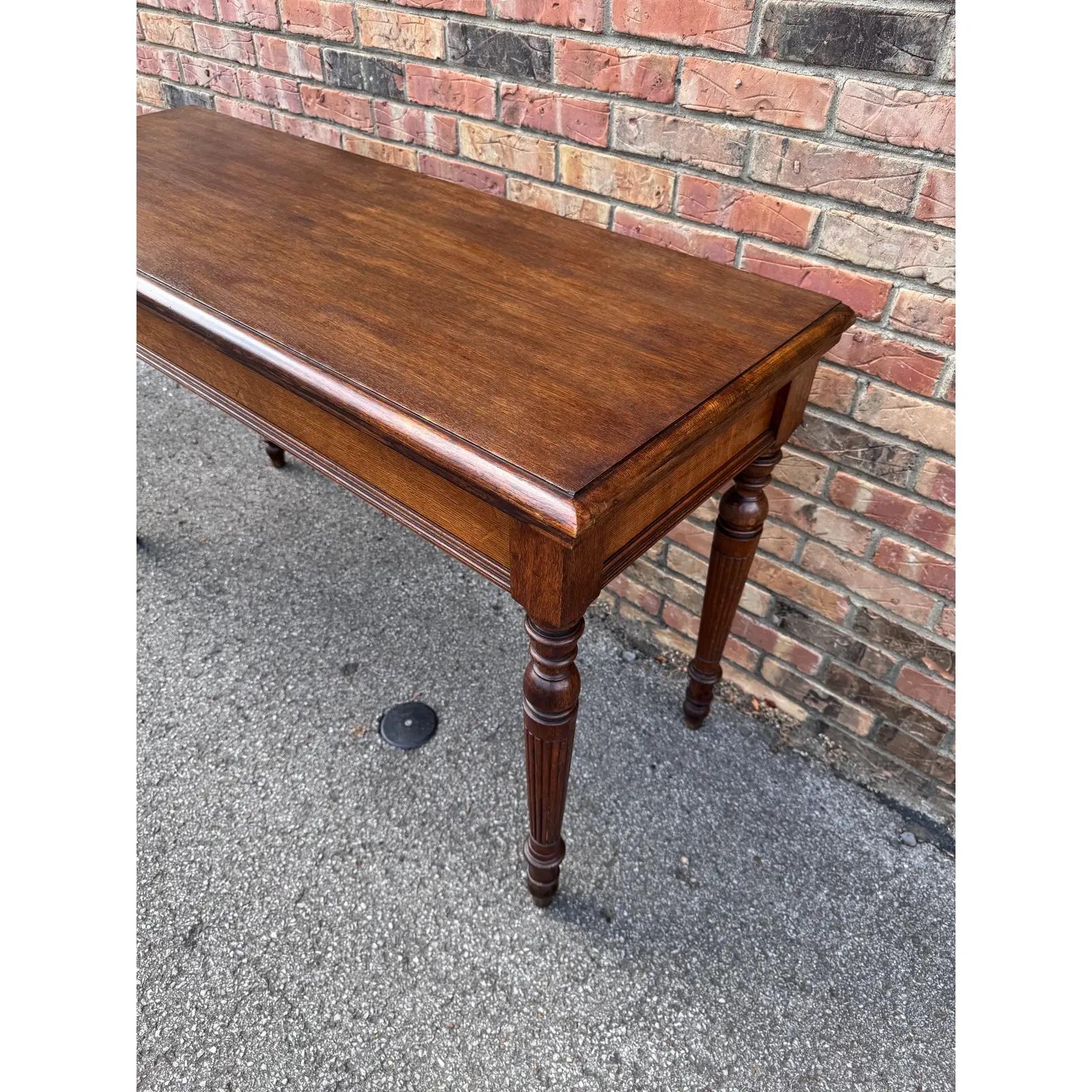 Cette table console anglaise attrayante et intemporelle a une forme rectangulaire, reposant sur quatre pieds tournés cannelés, et présente une belle finition en acajou. D'une taille polyvalente et d'une patine attrayante, il ajoute du caractère à