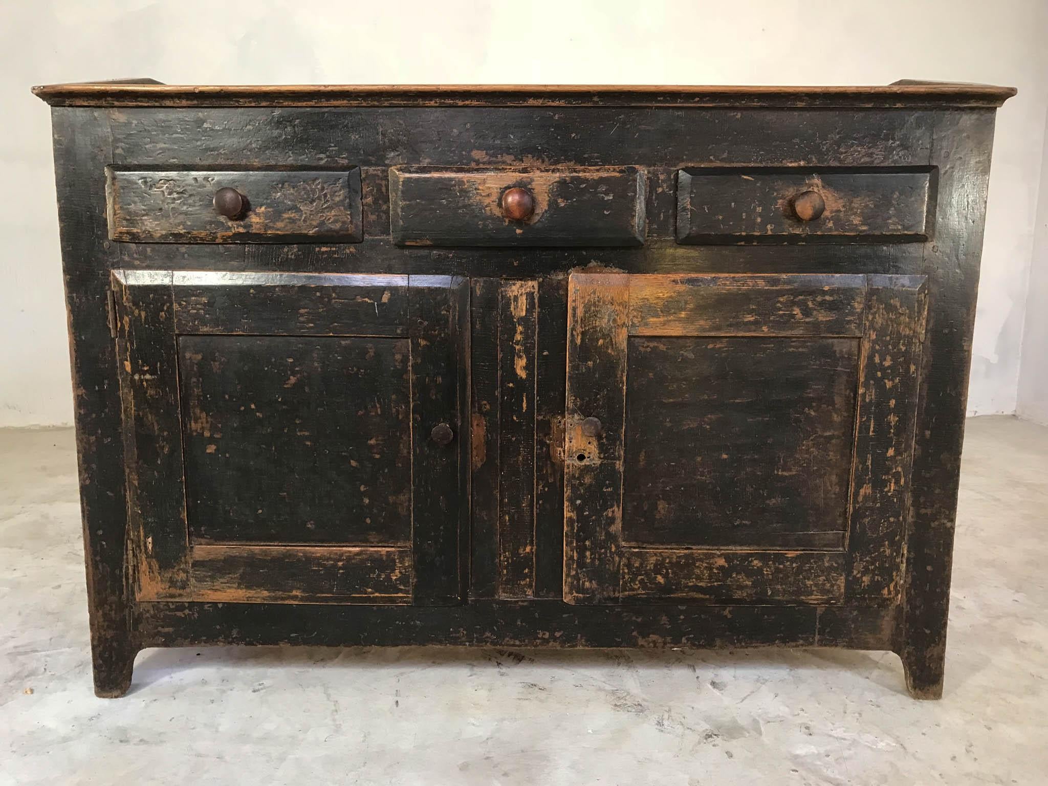 A very rare English sideboard or cupboard with a deep storage area on top, dating from the 1880s. Unusually, it has been made from oak and features jointed panels, later but very old paint that is almost black, original backboards, three drawers and