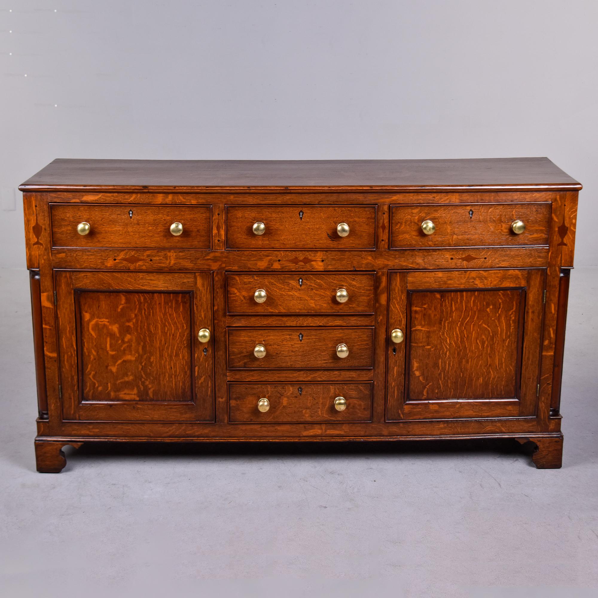 Found in England, this circa 1860s oak chest has 6 drawers and 2 cabinets with brass hardware. This piece was originally the base and would have had an additional, taller cabinet that sat on top. Beautifully constructed with nicely figured oak,