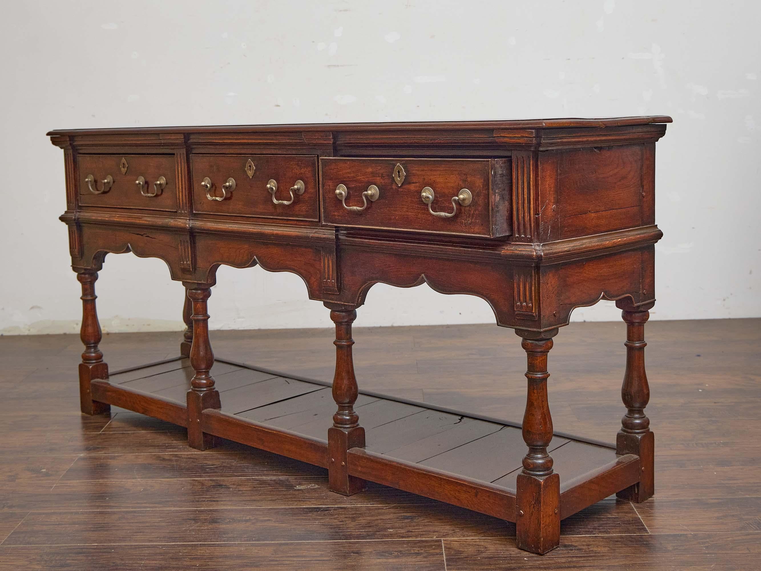 Sculpté Base de commode en chêne anglais du 19e siècle avec trois tiroirs et une étagère ouverte en vente
