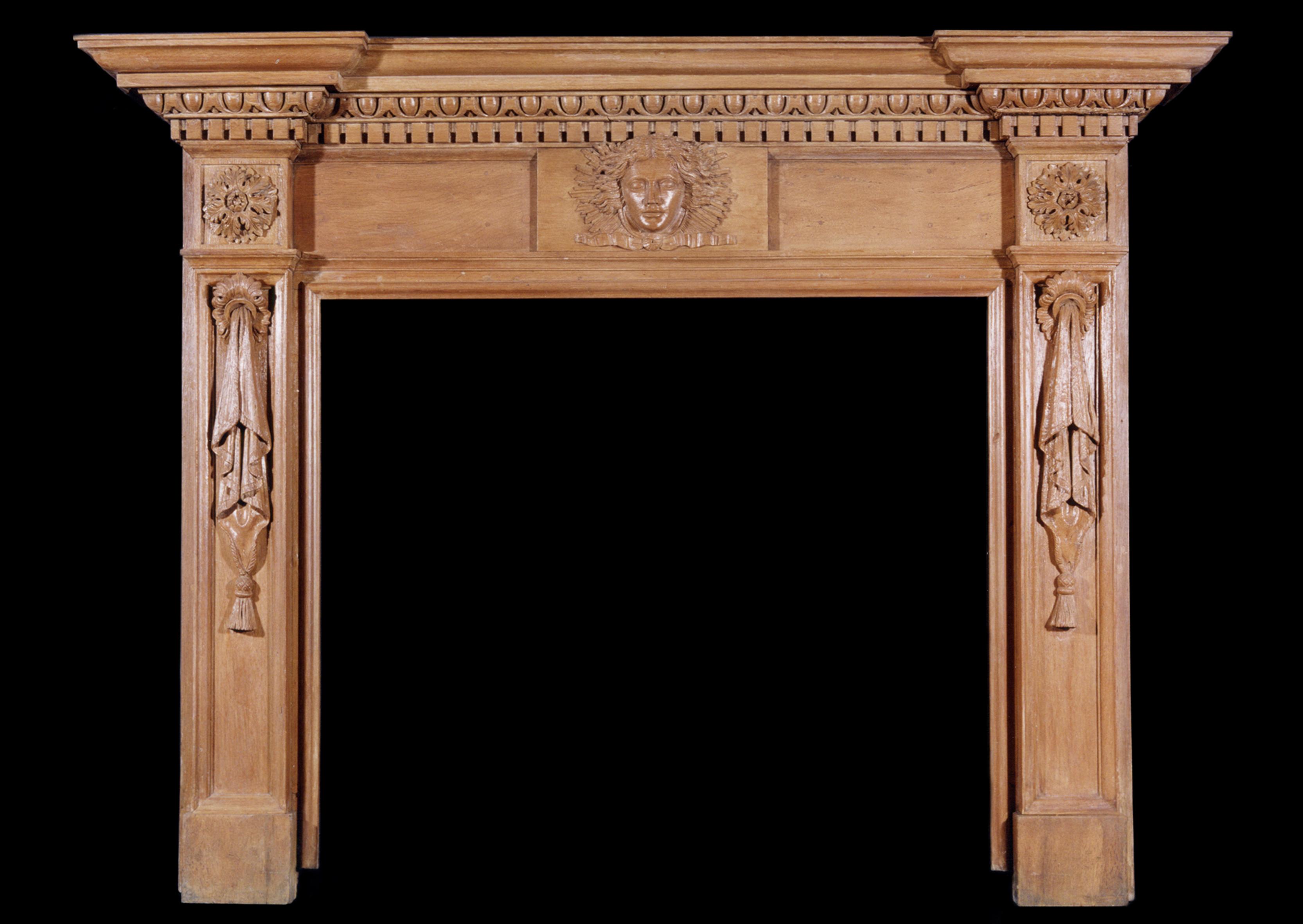 A 19th century English oak fireplace with carved mask to centre, egg and dart dentil cornice, jambs with drapery surmounted by leaf pateras.

Measures: 
Shelf Width:	1905 mm      	75 in
Overall Height:	1440 mm      	56 3/4 in
Opening Height:	1030 mm