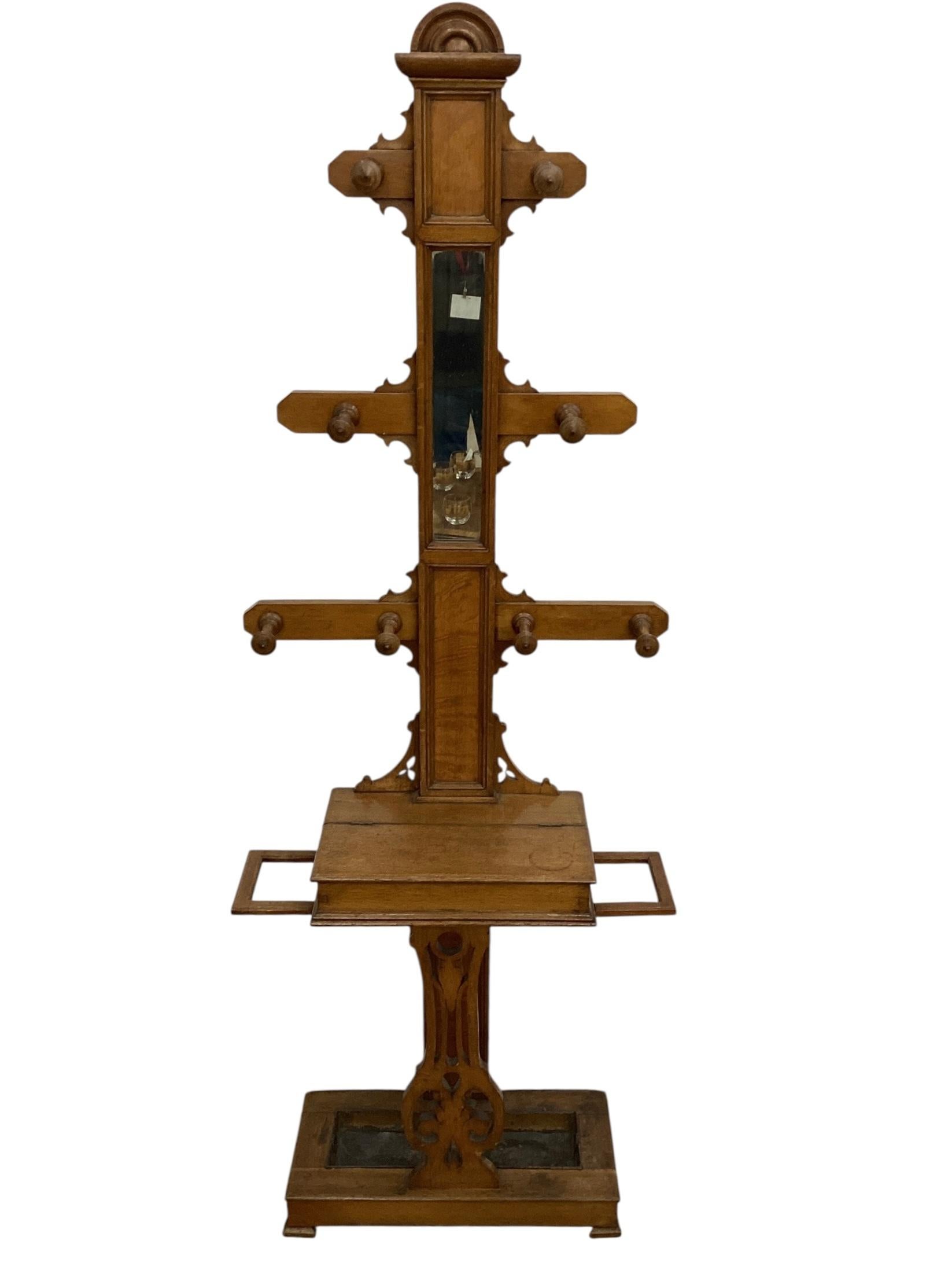 19th Century English Oak Hall Tree with multiple spindles for hanging coats and hats. The tree has a mirror as well a hinged compartment for storage. It also has a drip pan with an umbrella holder. In overall good condition with age cracks and a