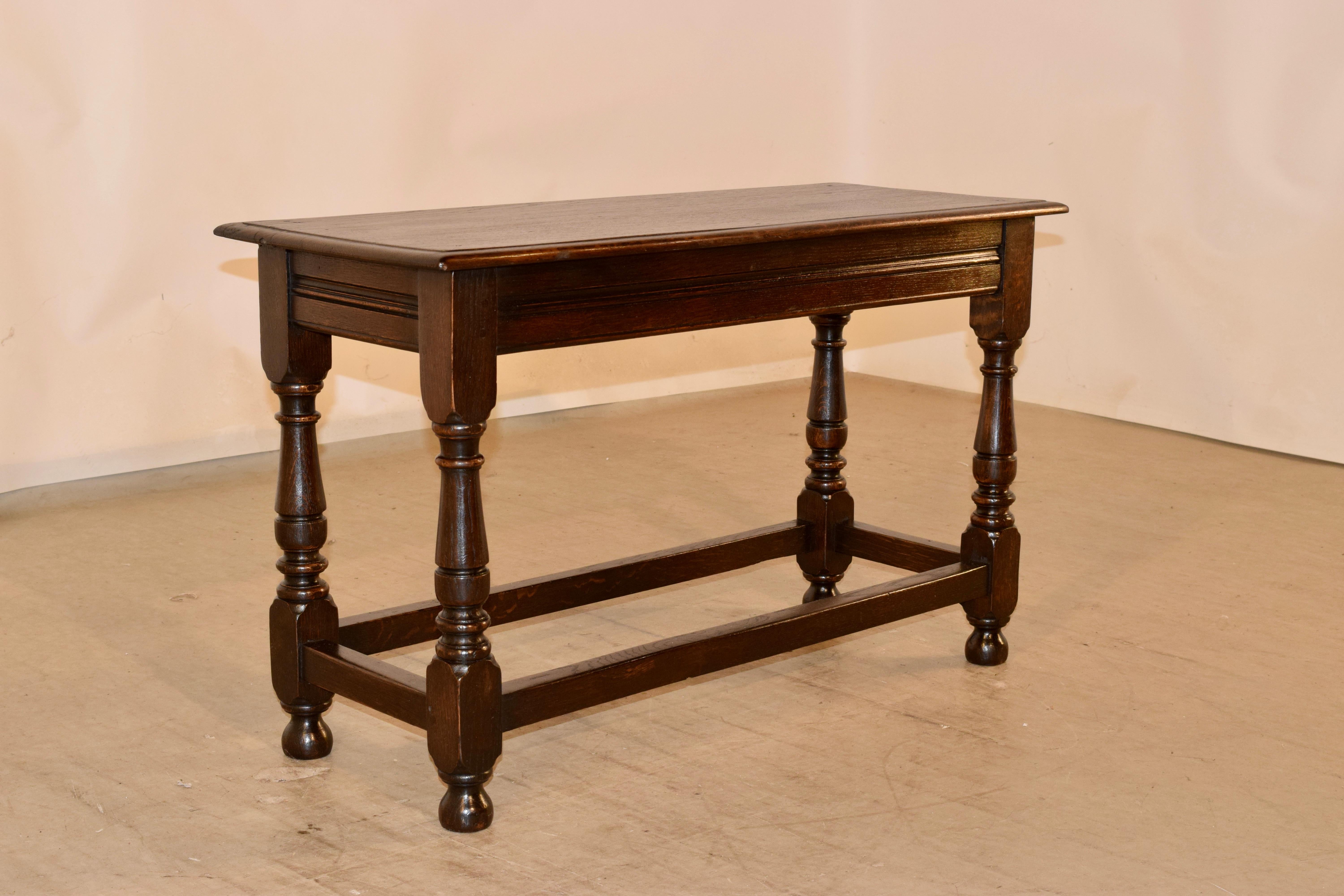 19th century oak joint bench with a beveled edge around the top, following down to a molded apron and supported on hand turned legs, joined by simple stretchers and raised on hand turned feet.