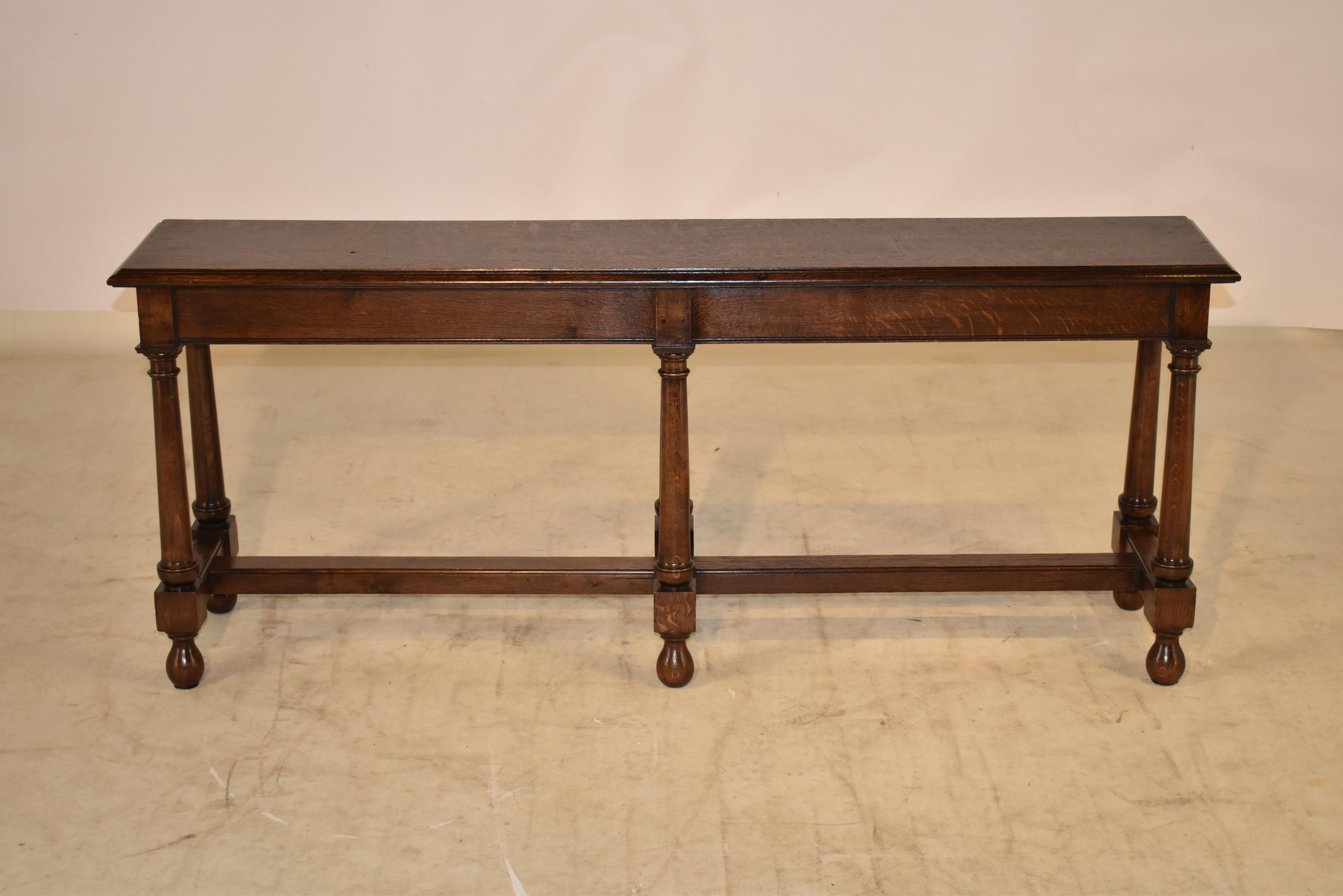 19th century oak joint bench from England with a single plank top which has a beveled edge, following down to a simple apron and supported on splayed legs, joined by simple stretchers and raised on hand turned feet.  