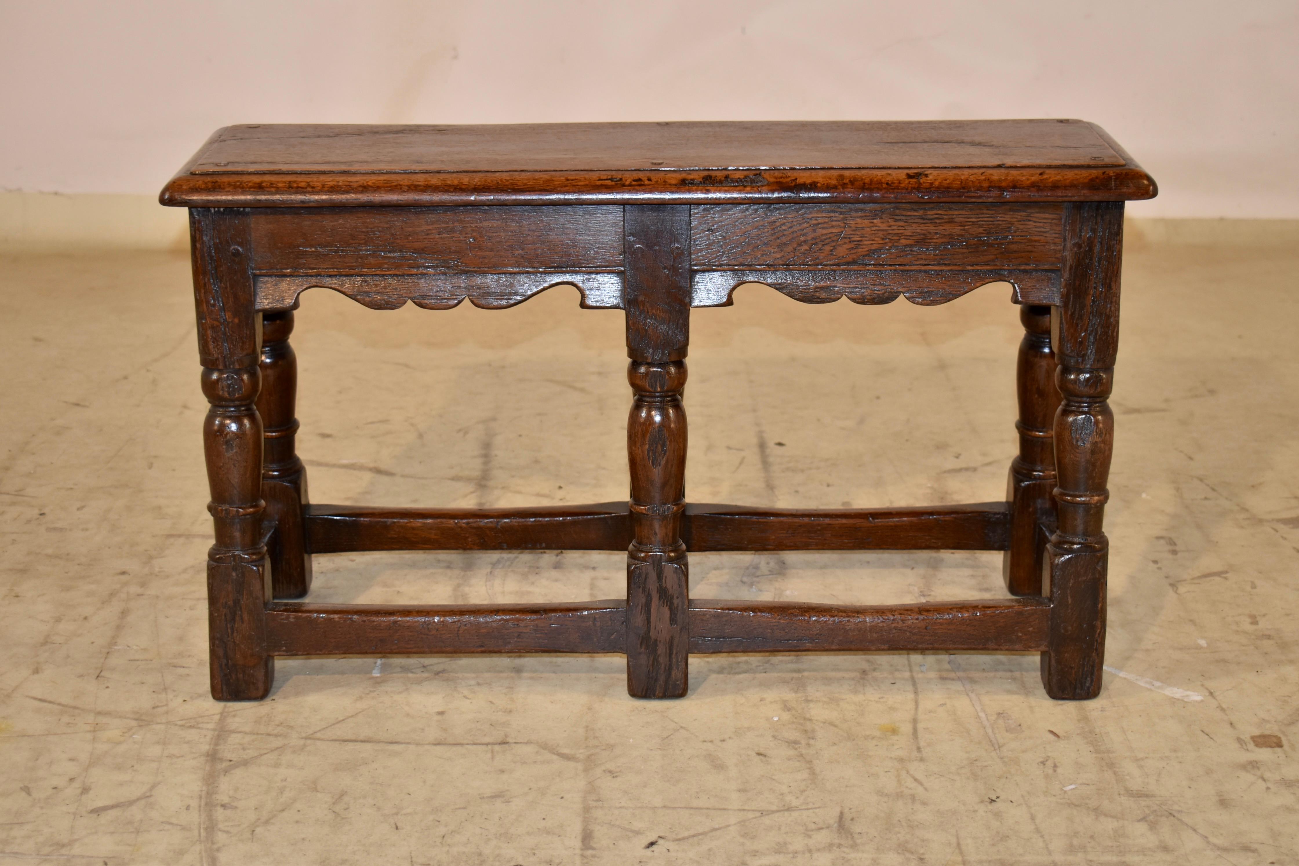 Banc en chêne du 19e siècle provenant d'Angleterre.  Le plateau est constitué d'une seule planche, dont le bord est biseauté et la construction chevillée.  La partie supérieure descend jusqu'à un tablier simple mais élégant avec des détails