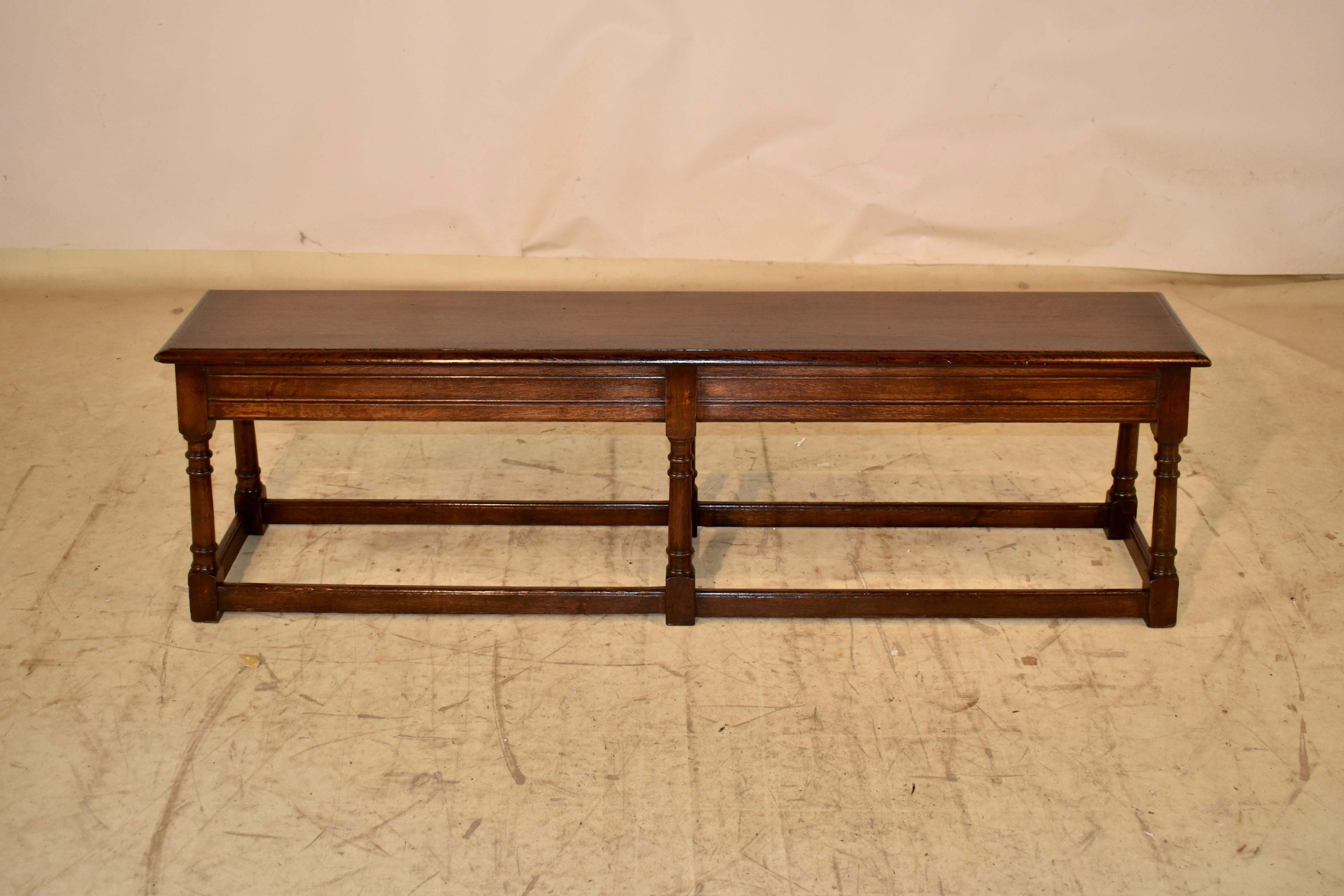 19th century oak joint bench from England.  

The top is nicely grained and has a beveled edge, following down to an elegantly paneled apron.  The bench is supported on hand turned and splayed legs, joined by simple stretchers. 

The bench has
