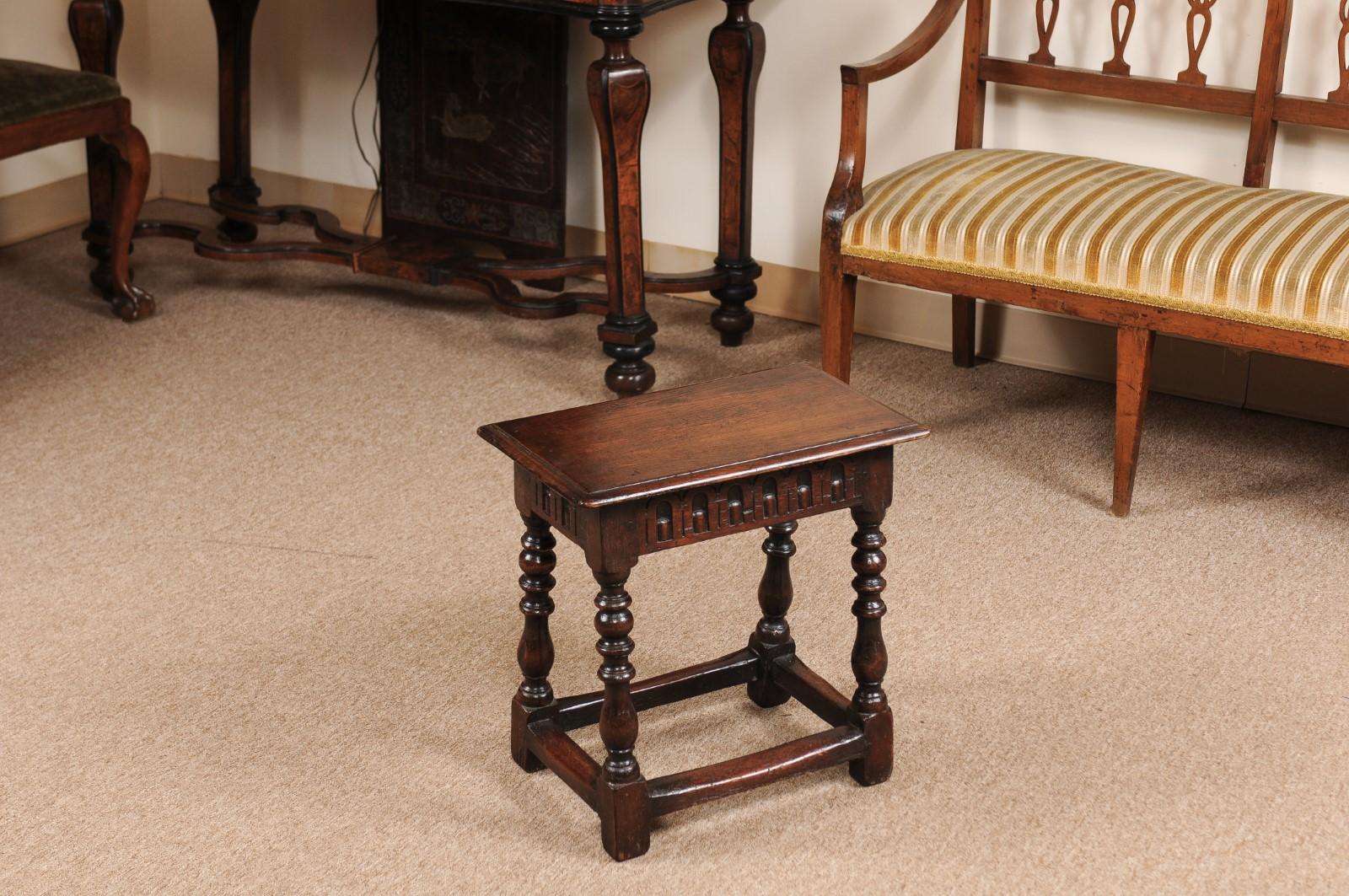 The 19th century English oak joint stool with carved frieze, turned legs and box stretcher.