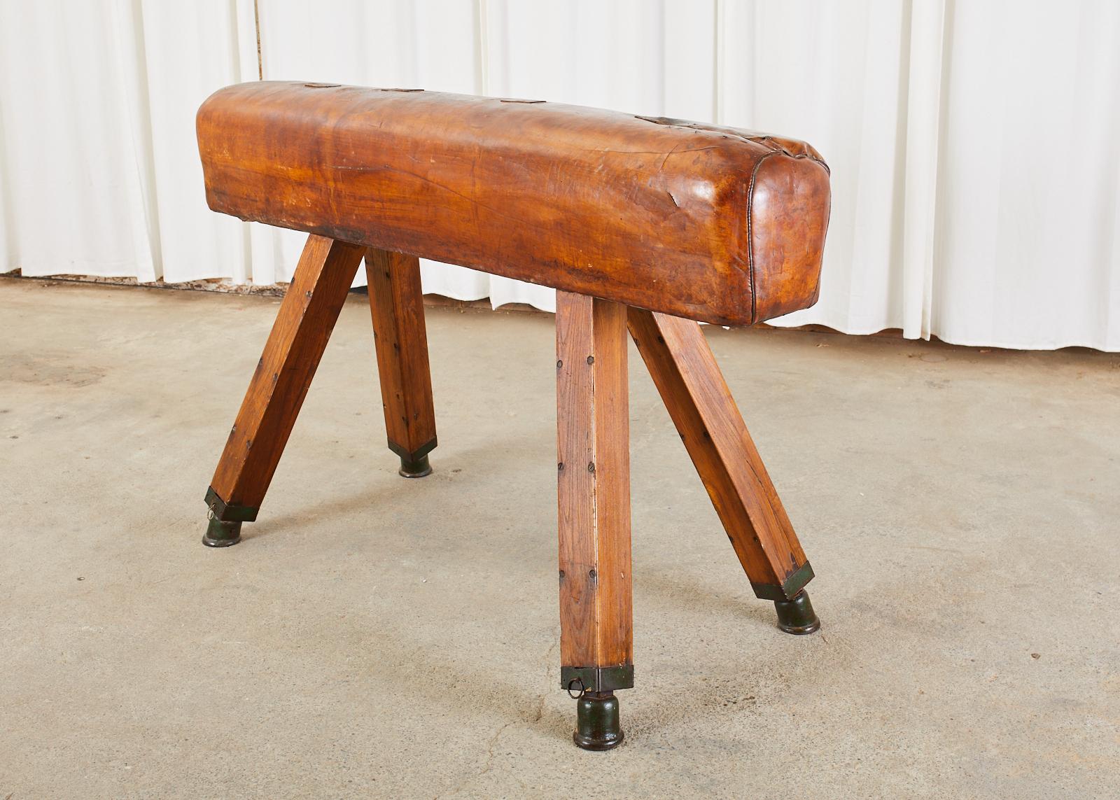 Large 19th century English gymnastic pommel horse or bench vault. Features an oak and iron frame covered with a rich patinated cognac leather. The leather cover is complete and pliable with several old repairs that add character and charm to the