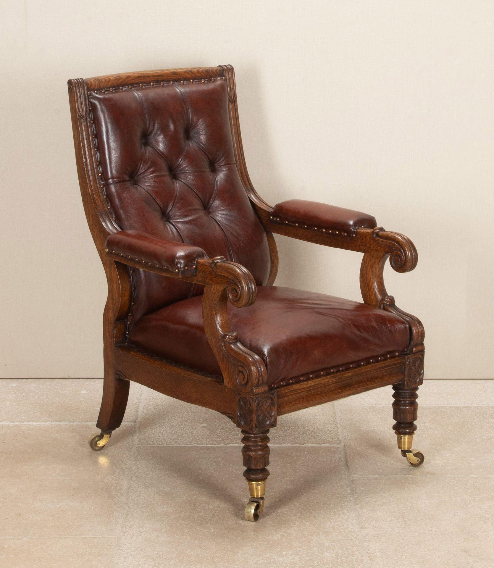 A fantastic quality 19th Century English carved oak library open arm chair of generous proportions. The shapely back with carved lappets and moulded frame leading onto scrolled arm supports with further lappets below and carved gothic quatrefoils