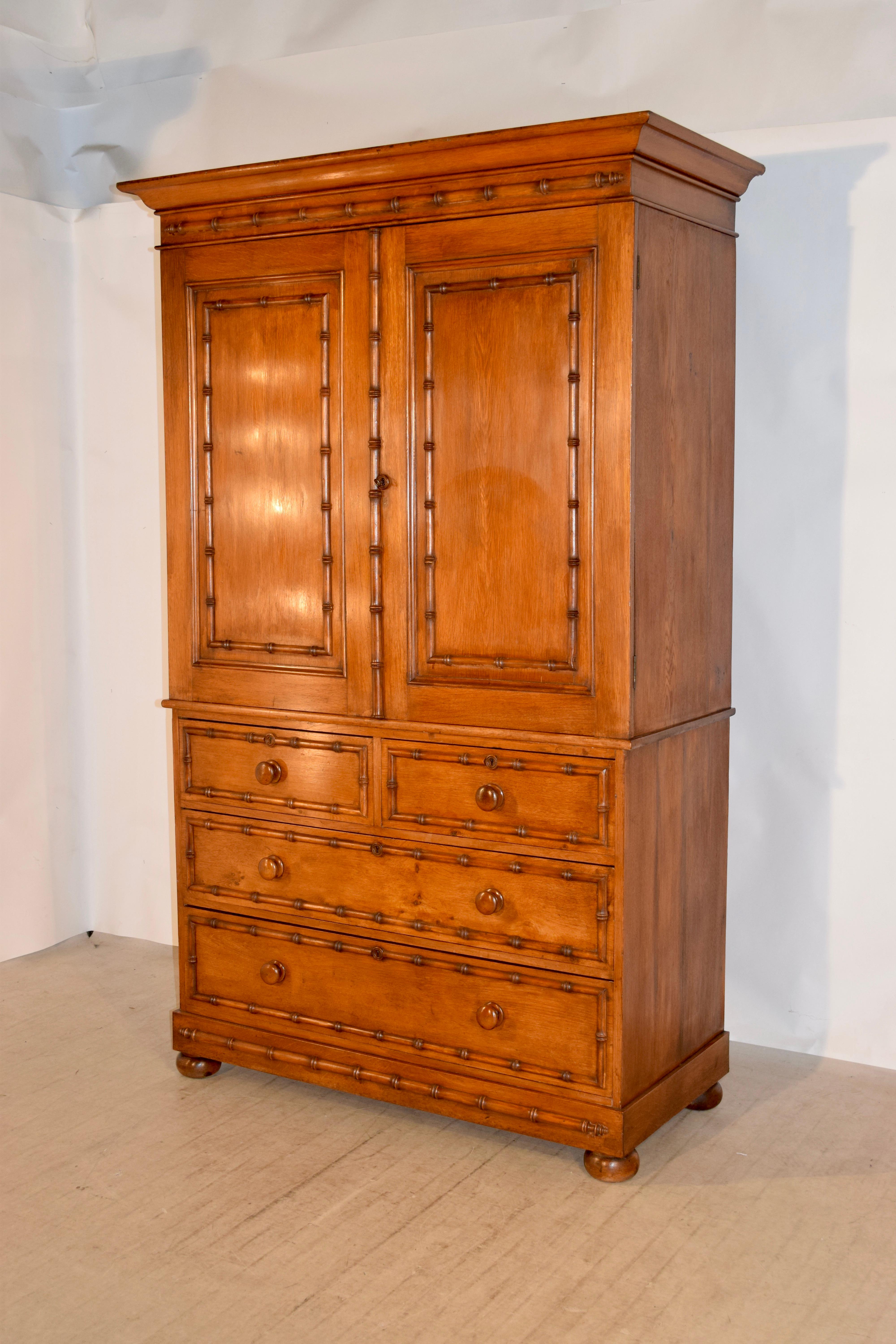 19th century linen press from England made from oak. The top is decorated with a crown molding over two paneled doors, both with applied faux bamboo moldings and simple sides. The doors open to reveal three pull out linen shelves, all with original